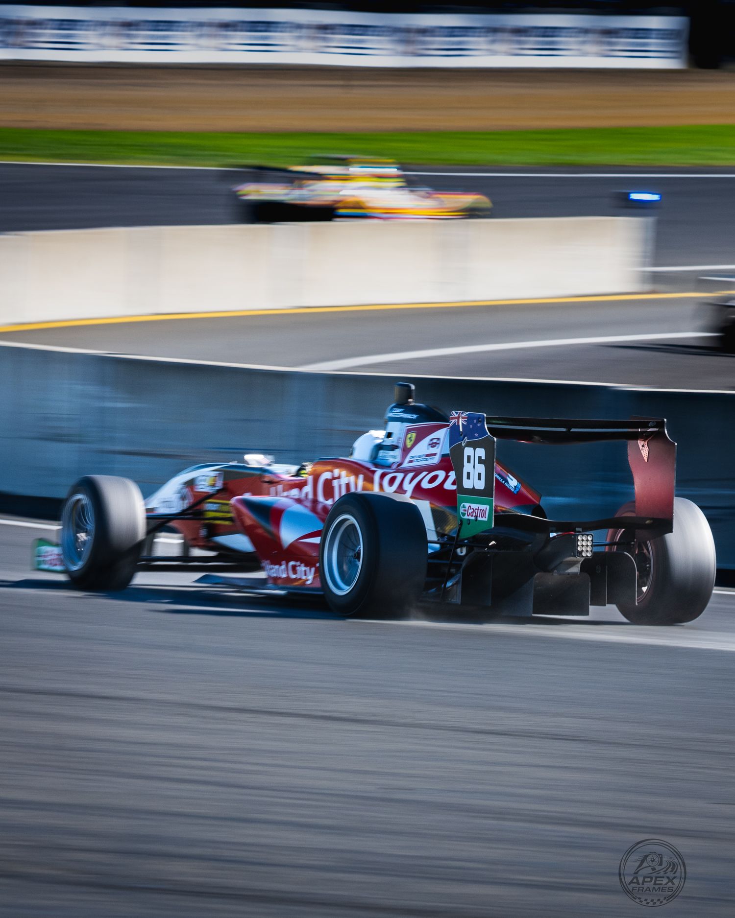 Auckland City Toyota formula car #86 cornering at speed on a racing circuit at dusk.