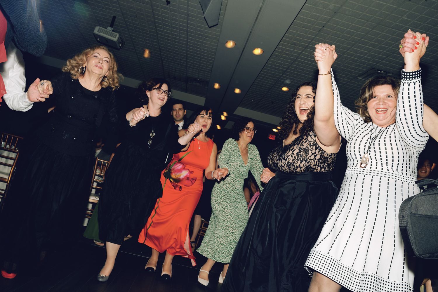 Women dancing with raised hands at The Manor in King City during a joyful Jewish wedding reception celebration.