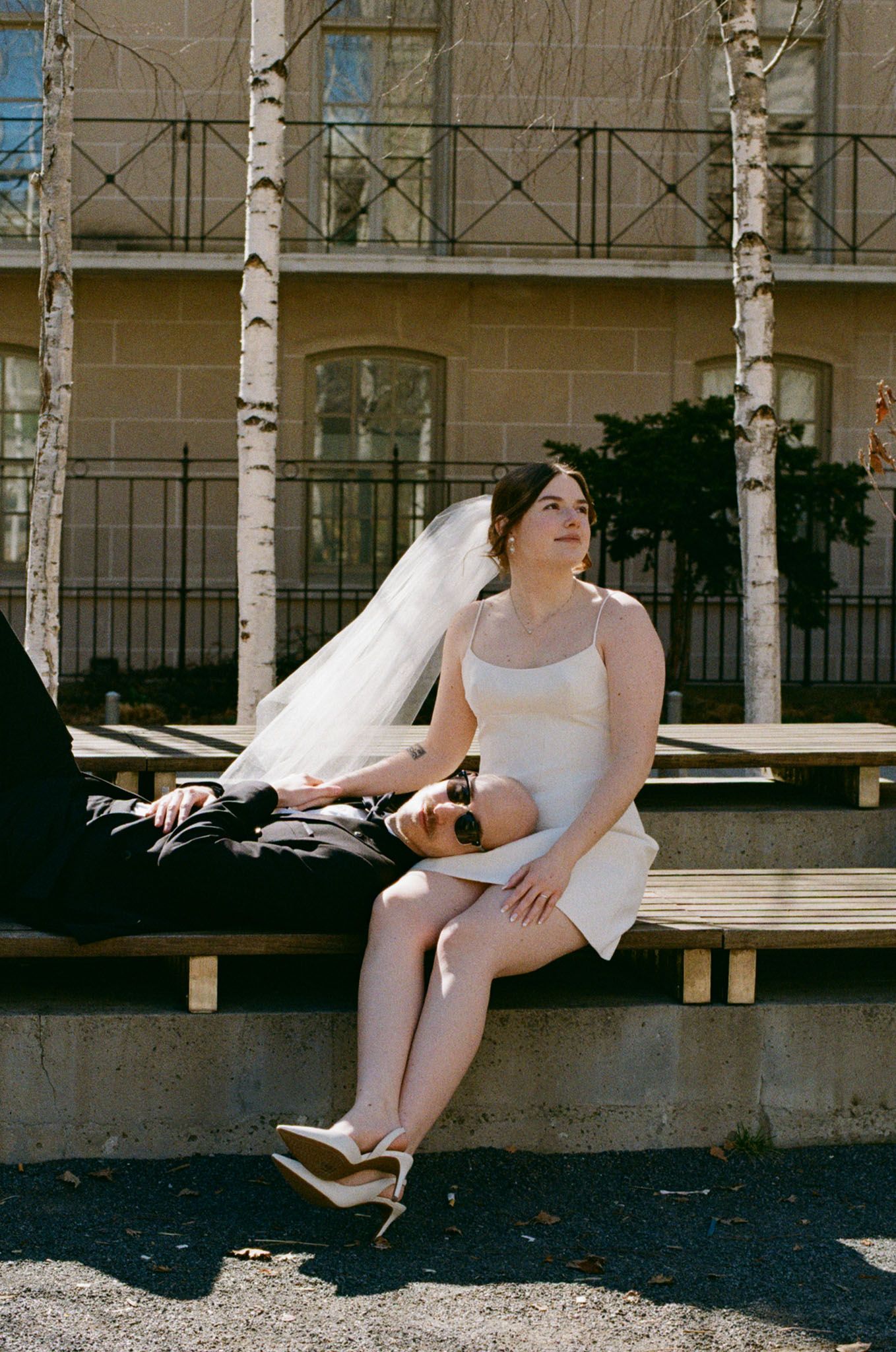 Bride and groom relaxing on the steps outside Osgoode Hall for editorial Toronto City Hall wedding portraits