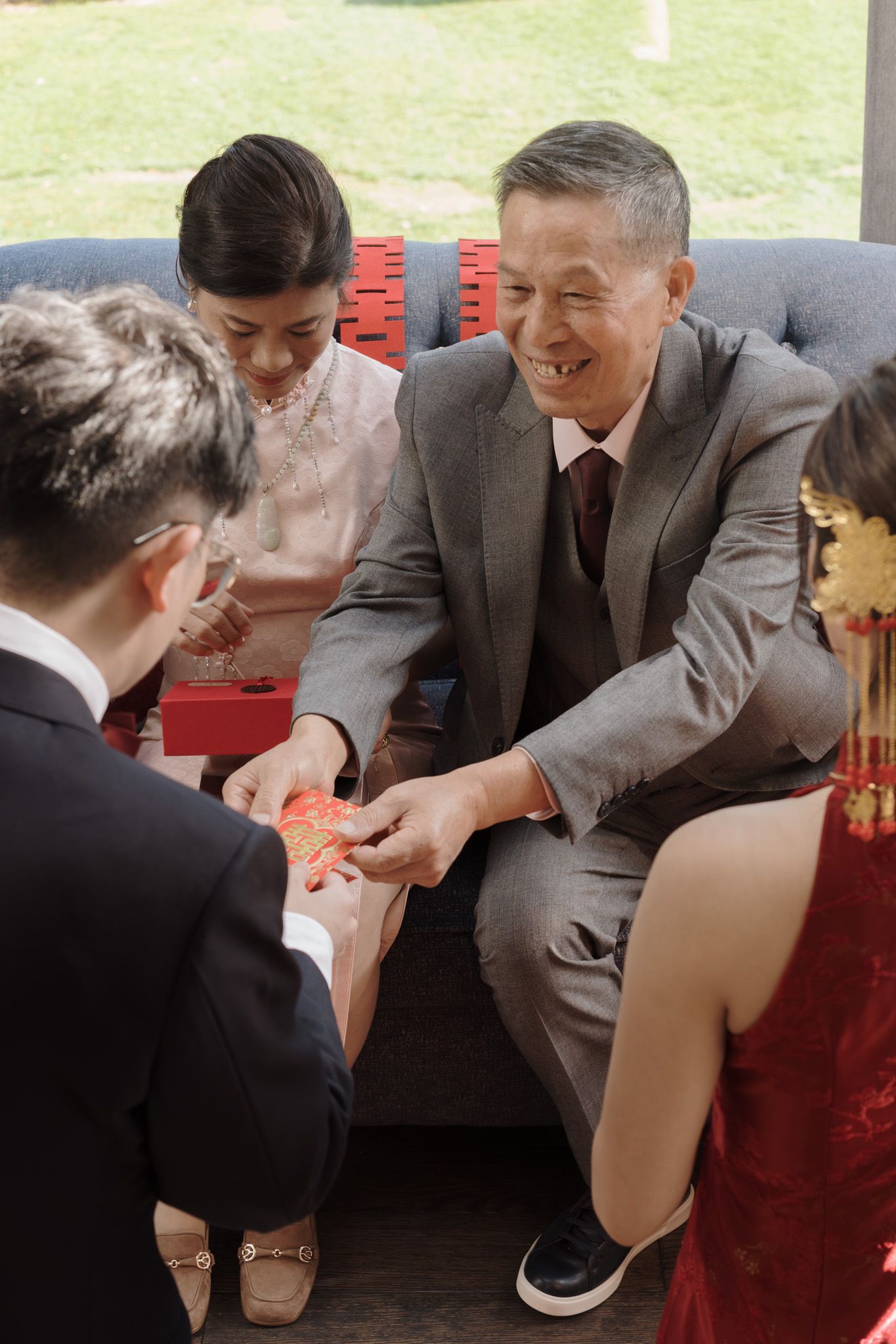 Family exchanging red envelopes with smiling elders during a Chinese tea ceremony at Razi Estate in Schomberg.