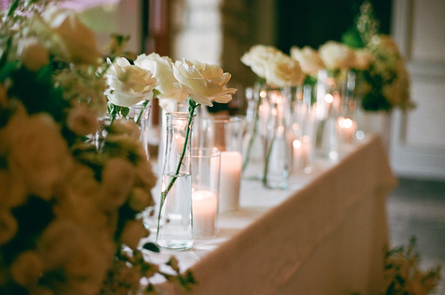 White rose table décor with glowing candles at Cambridge Mill in Cambridge, Ontario for romantic wedding reception photography.