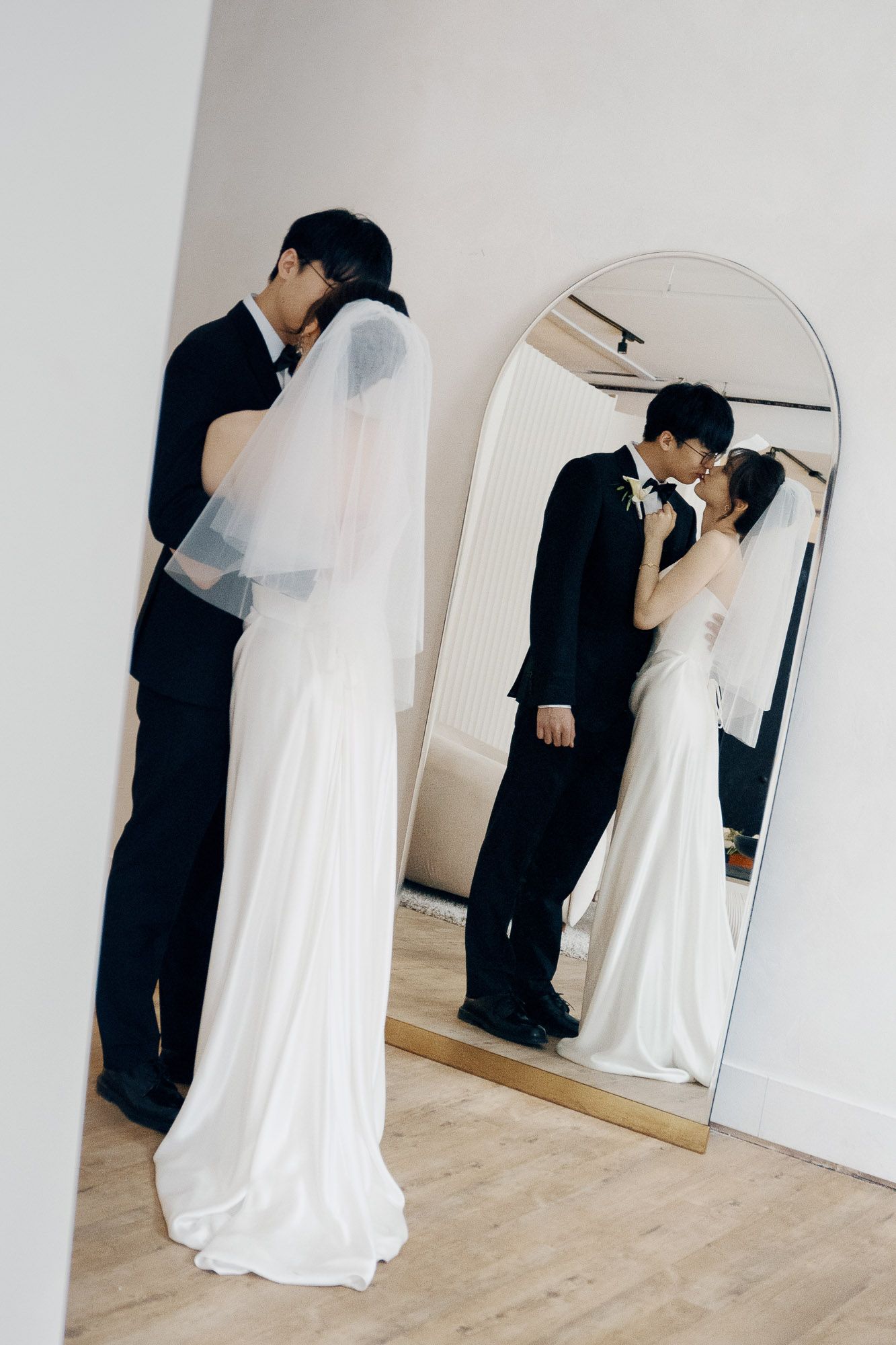 Bride and groom kissing in an arched mirror reflection at Archive Studio in Toronto for intimate wedding photography.