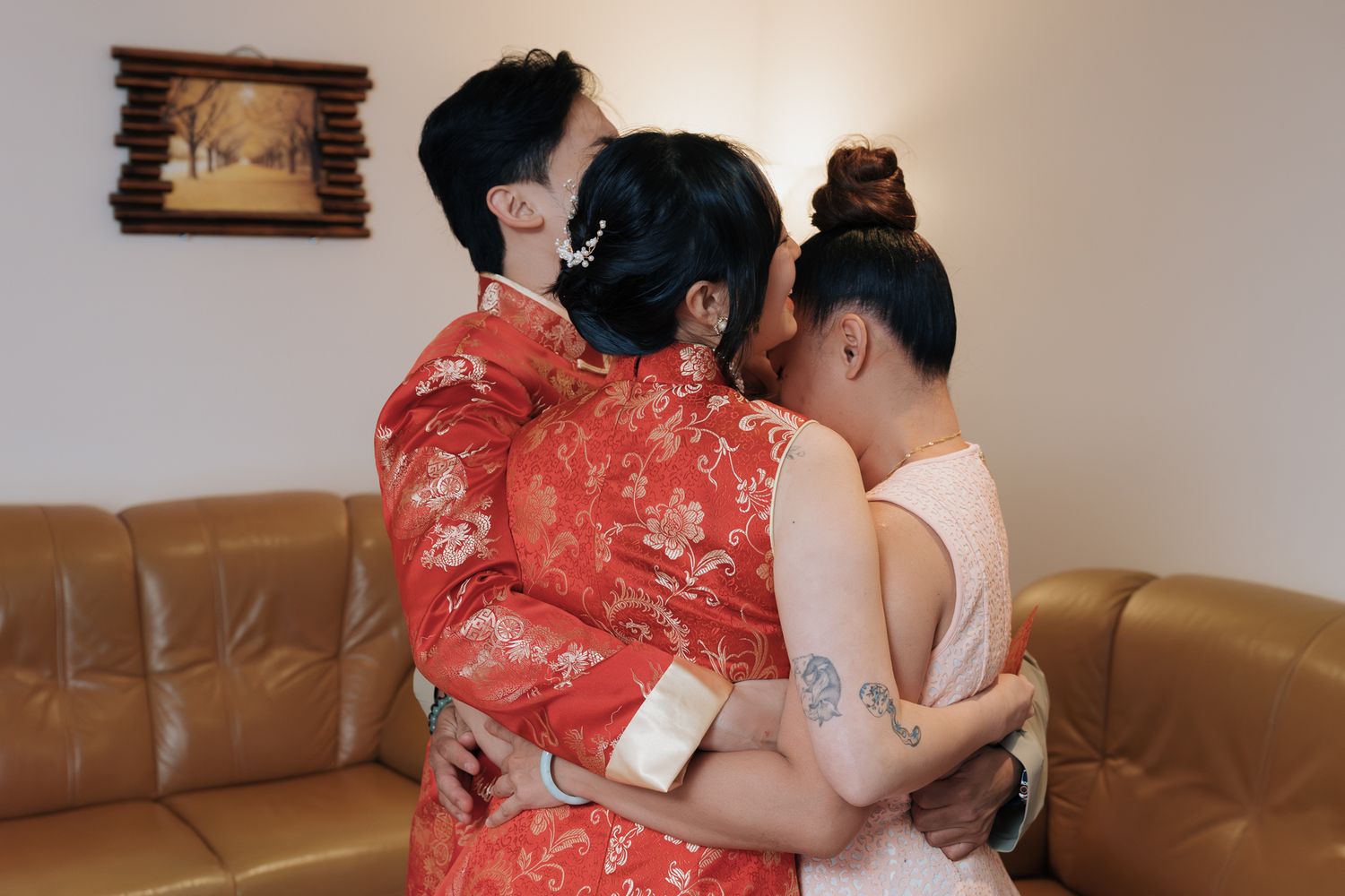 Emotional embrace during a traditional Chinese tea ceremony in Toronto, with bride wearing a red qipao.