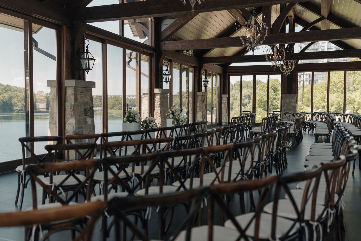 Rustic ceremony chairs beneath vaulted ceilings at Cambridge Mill in Cambridge, Ontario with scenic waterfront wedding views.