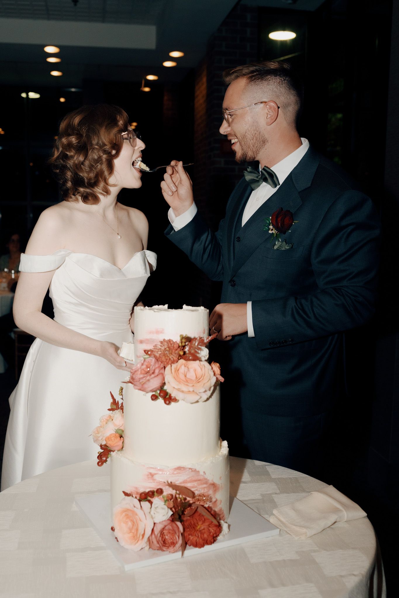 Bride and groom laughing while cutting wedding cake at The Manor in King City during their Jewish wedding reception