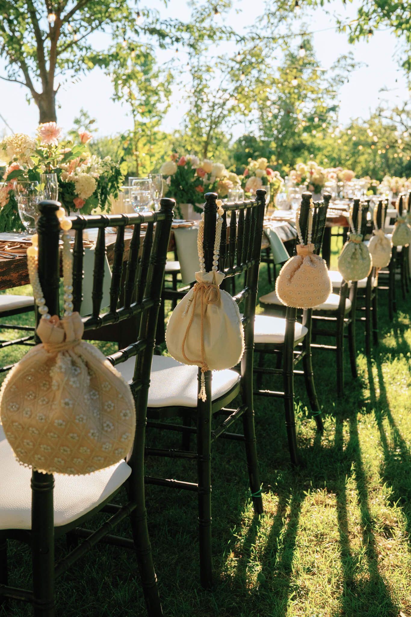 Dark Chiavari chairs with lace bags on a sunlit lawn at Kurtz Orchards in Niagara-on-the-Lake outdoor wedding ceremony.