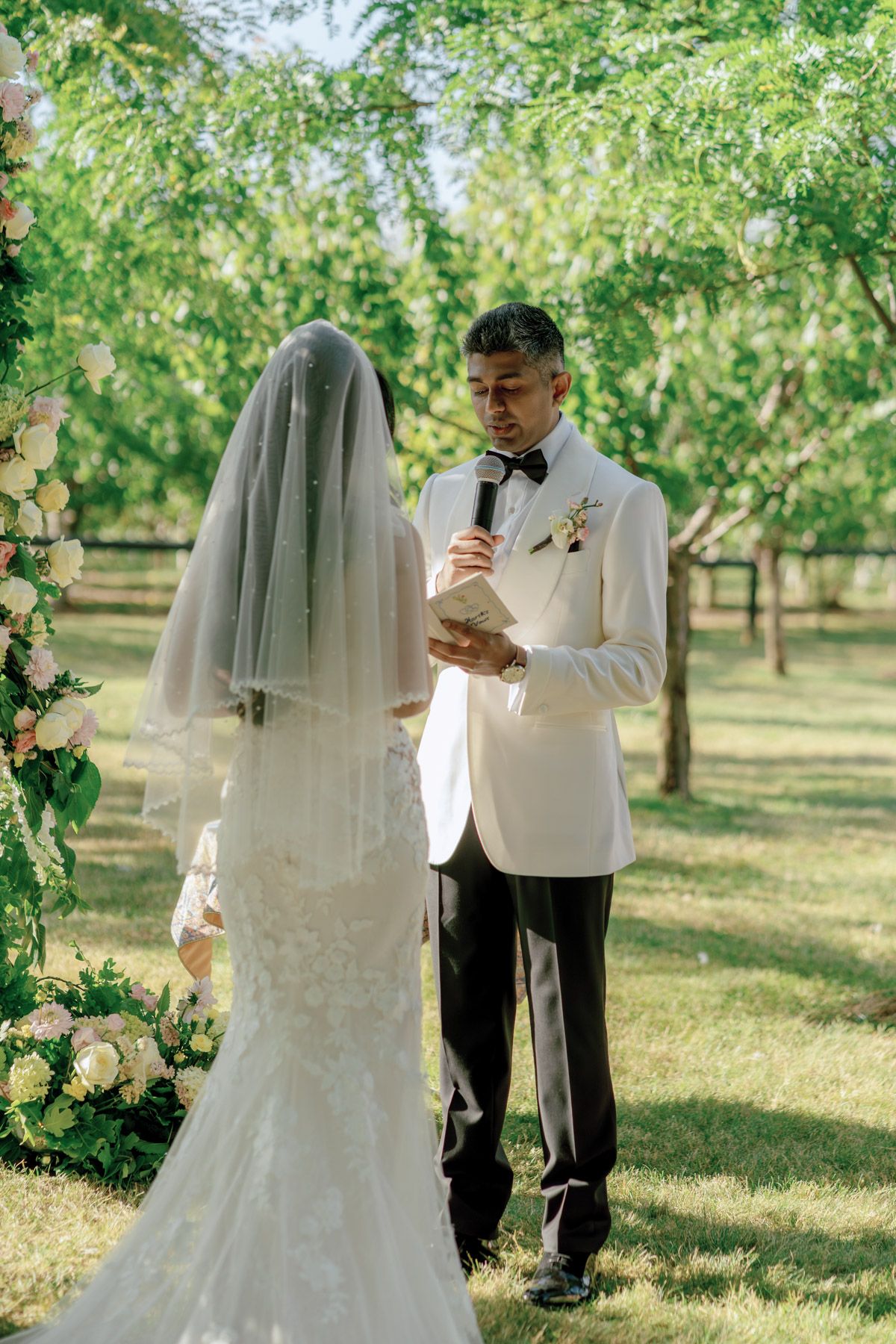 Bride signing wedding registry as groom stands behind her at Kurtz Orchards in Niagara-on-the-Lake outdoor wedding ceremony.