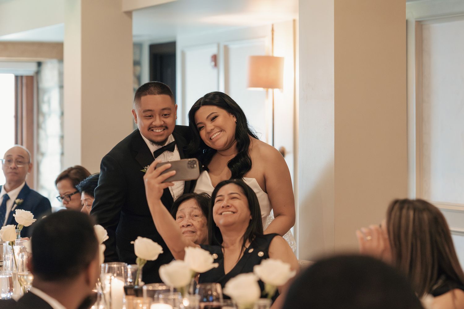 Bride and groom taking a selfie with guests at Cambridge Mill in Cambridge, Ontario during their candid wedding reception.