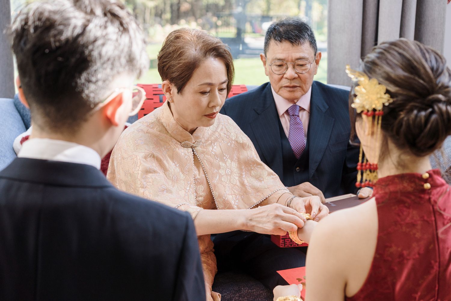 Elderly Chinese couple presenting a red envelope to bride in qipao during Chinese tea ceremony at Razi Estate in Schomberg.