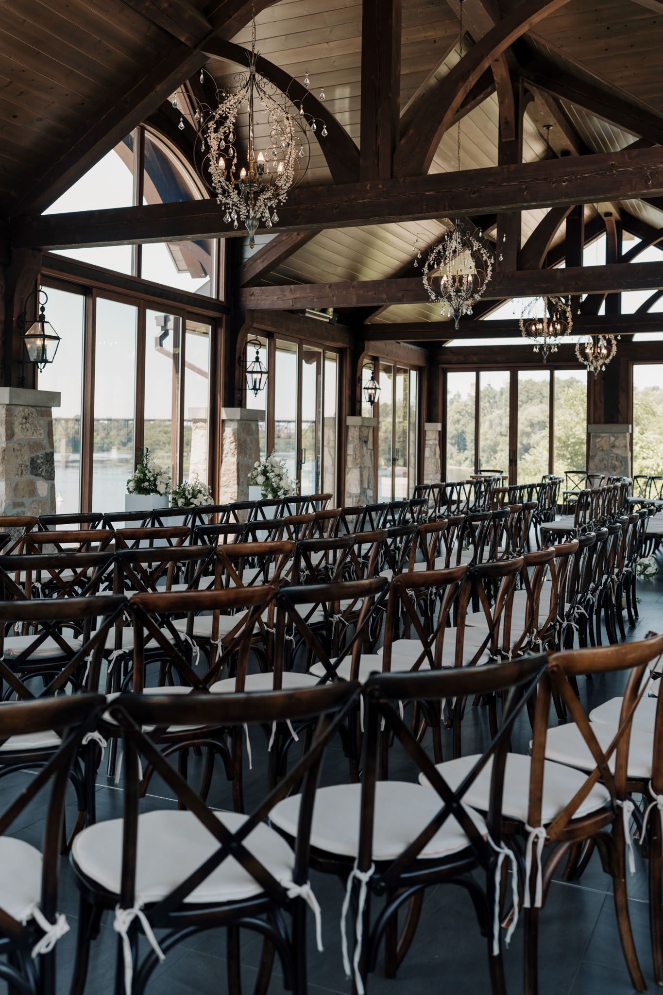 Elegant Cambridge Mill wedding venue with cross-back chairs, cathedral ceilings, chandeliers, and waterfront views in Cambridge, Ontario.