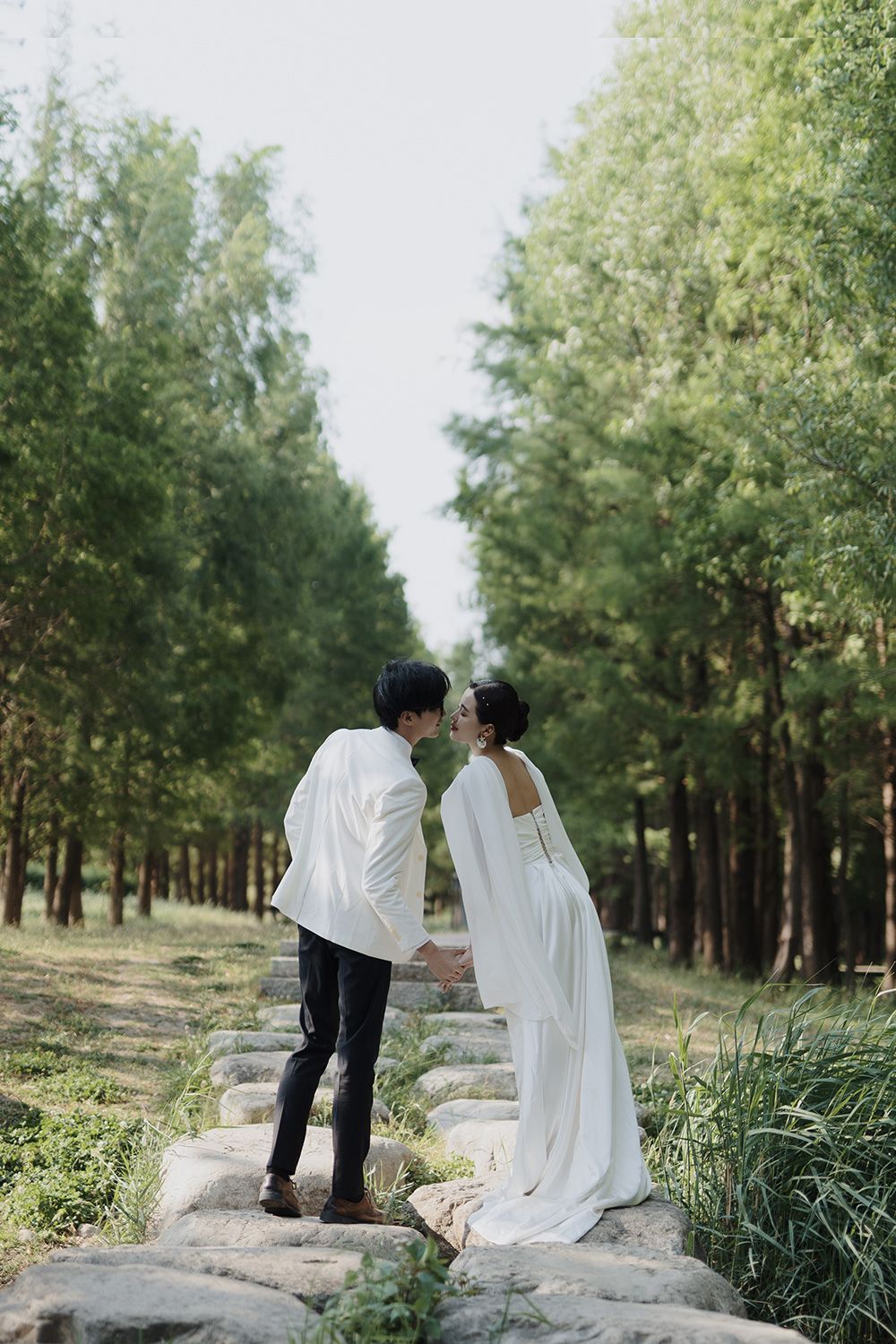 Couple sharing a romantic moment on stone steps in the forest during a Vancouver bridal portrait session for editorial wedding photography