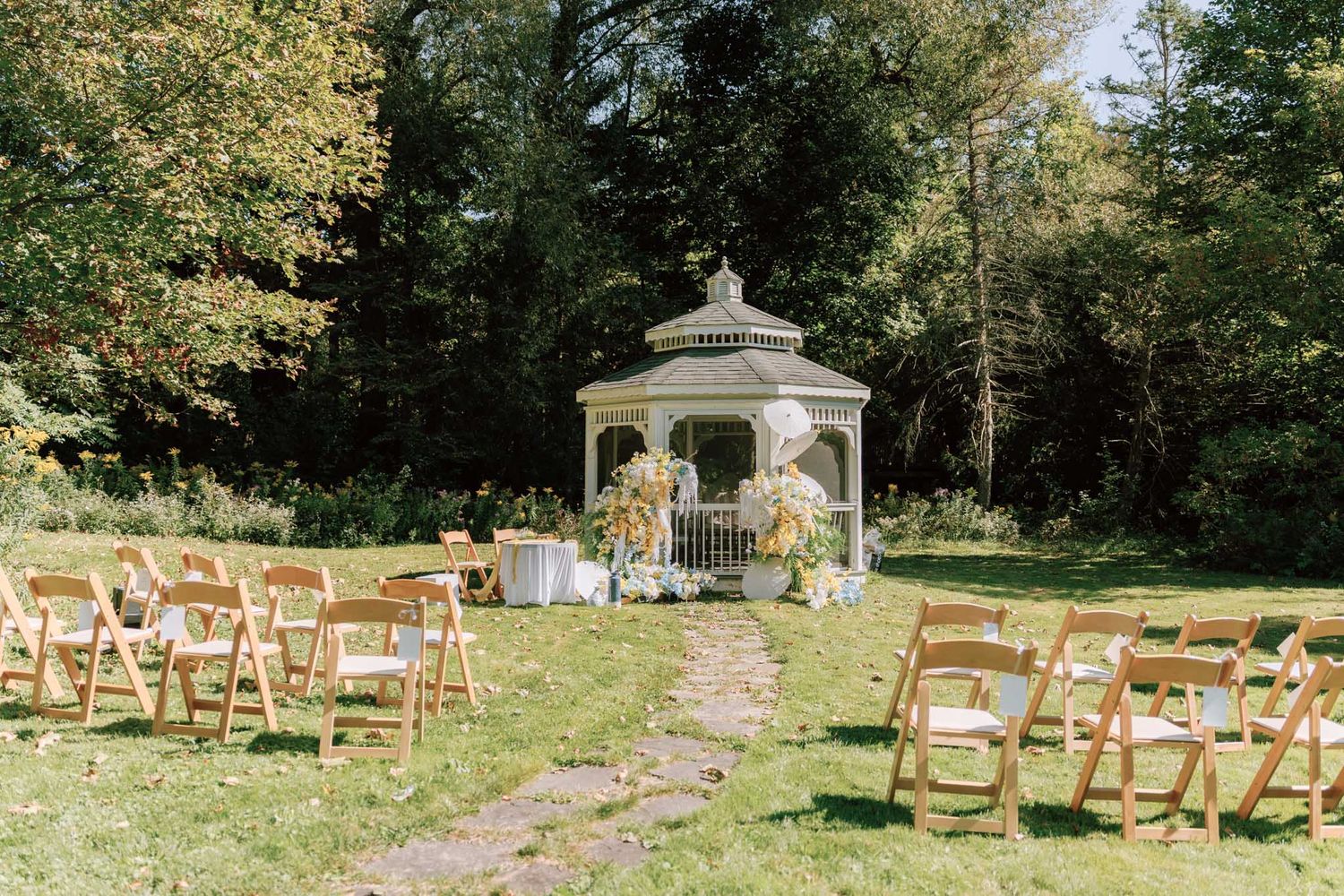 Outdoor wedding ceremony setup with wooden chairs and white gazebo at a Chinese estate venue for Toronto wedding photography