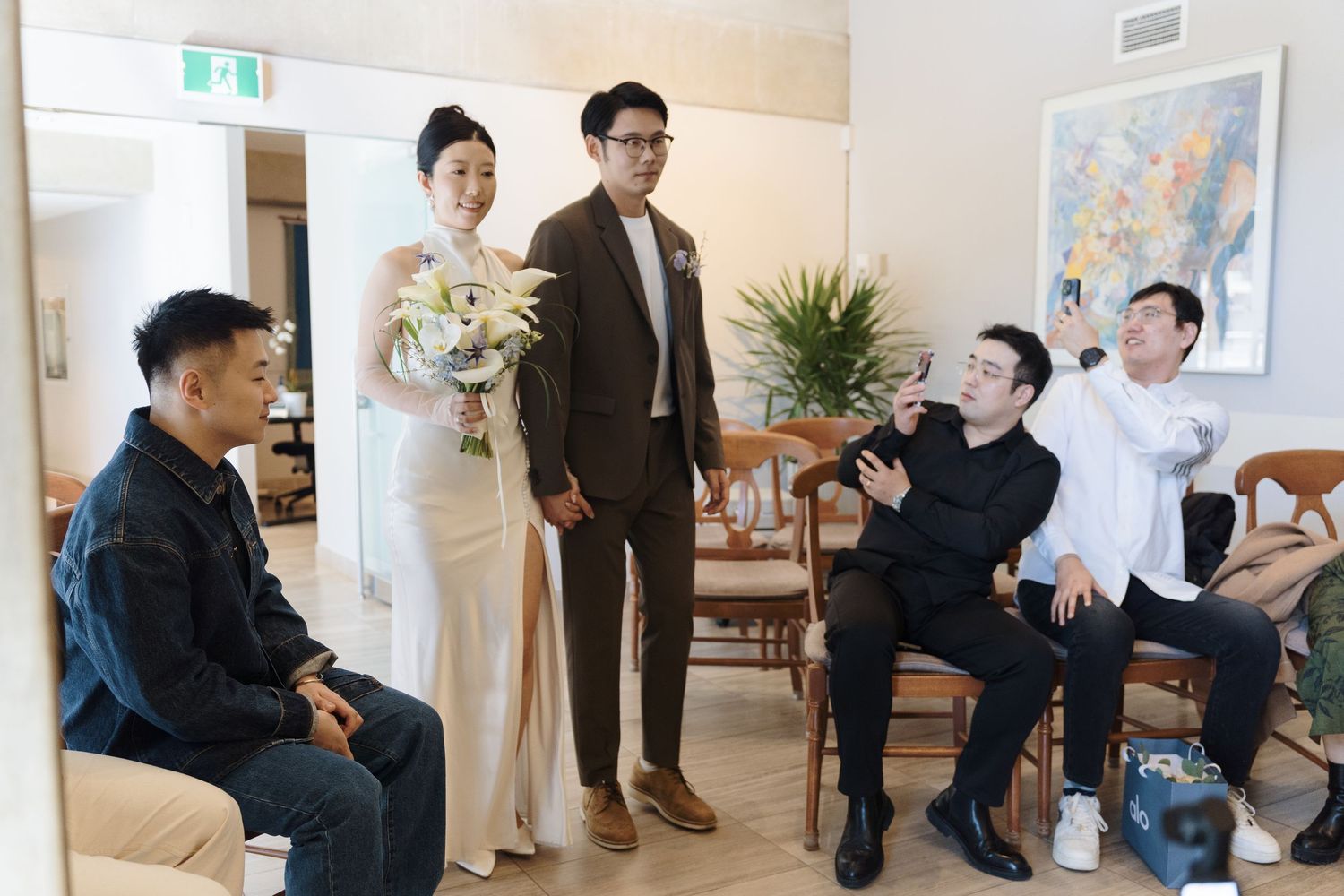 Bride and groom with guests in a bright modern room during their downtown Toronto City Hall wedding celebration.