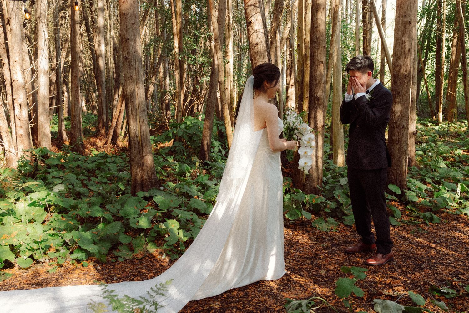Bride and groom sharing an emotional first look among tall trees at Razi Estate in Schomberg for cinematic forest wedding photography.