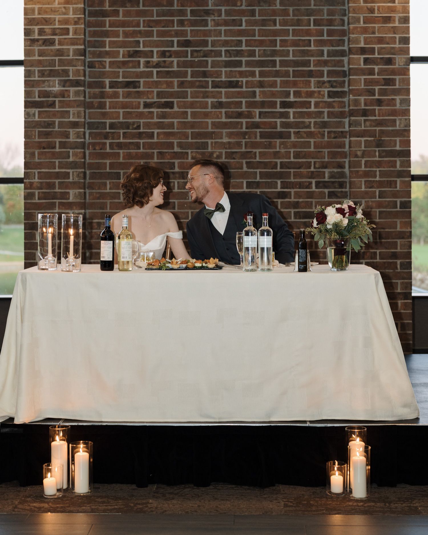 Bride and groom at their candlelit sweetheart table with florals at The Manor in King City during their Jewish wedding reception
