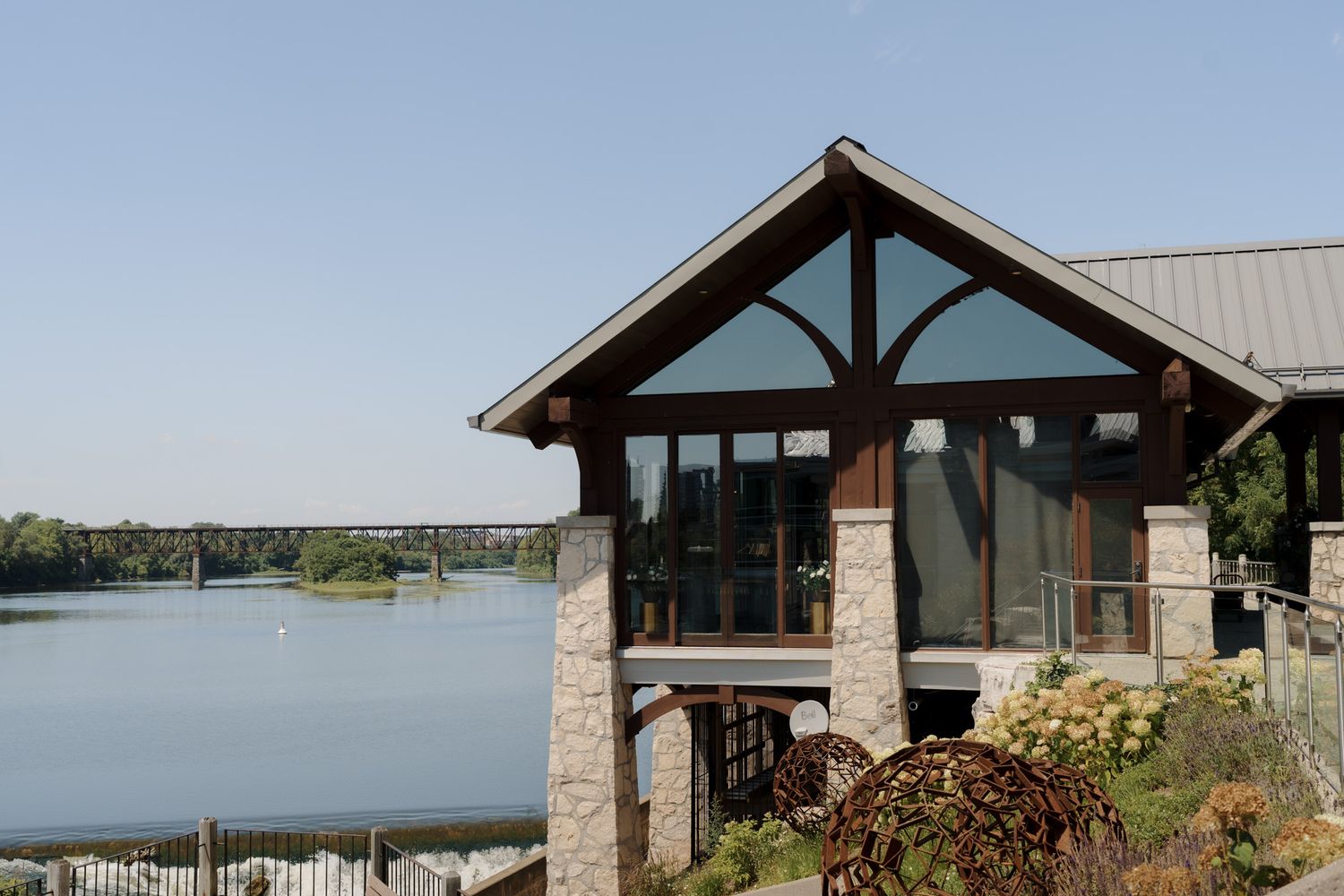 Scenic waterfront wedding venue with timber frame architecture and river views at Cambridge Mill in Cambridge, Ontario.