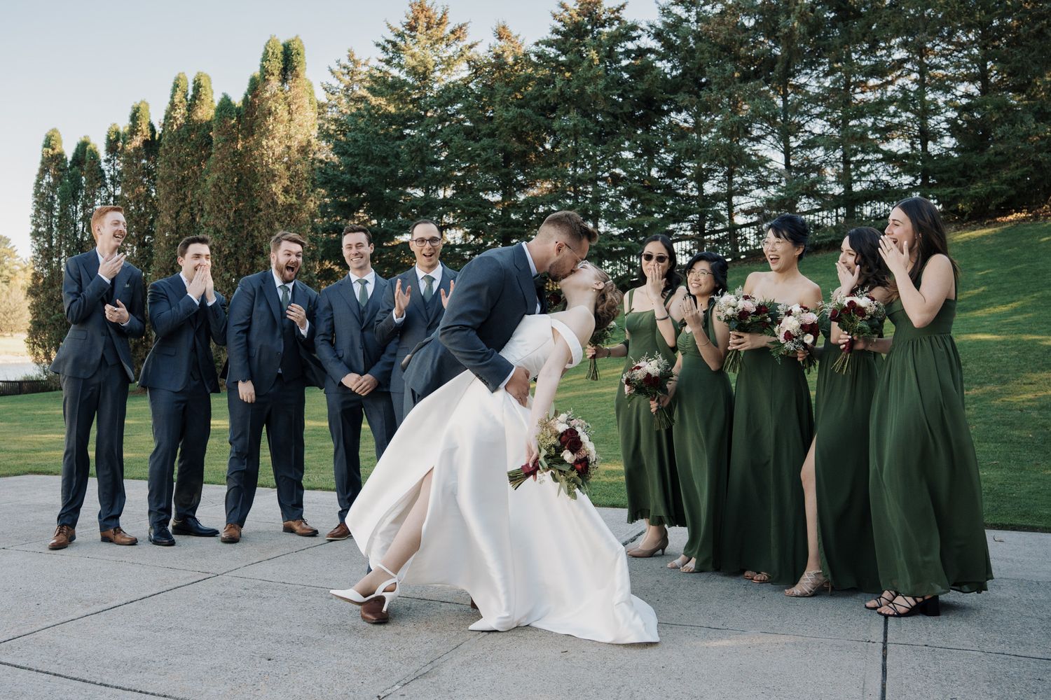 Bride and groom share a dip kiss as their wedding party cheers at The Manor in King City during a joyful Jewish wedding
