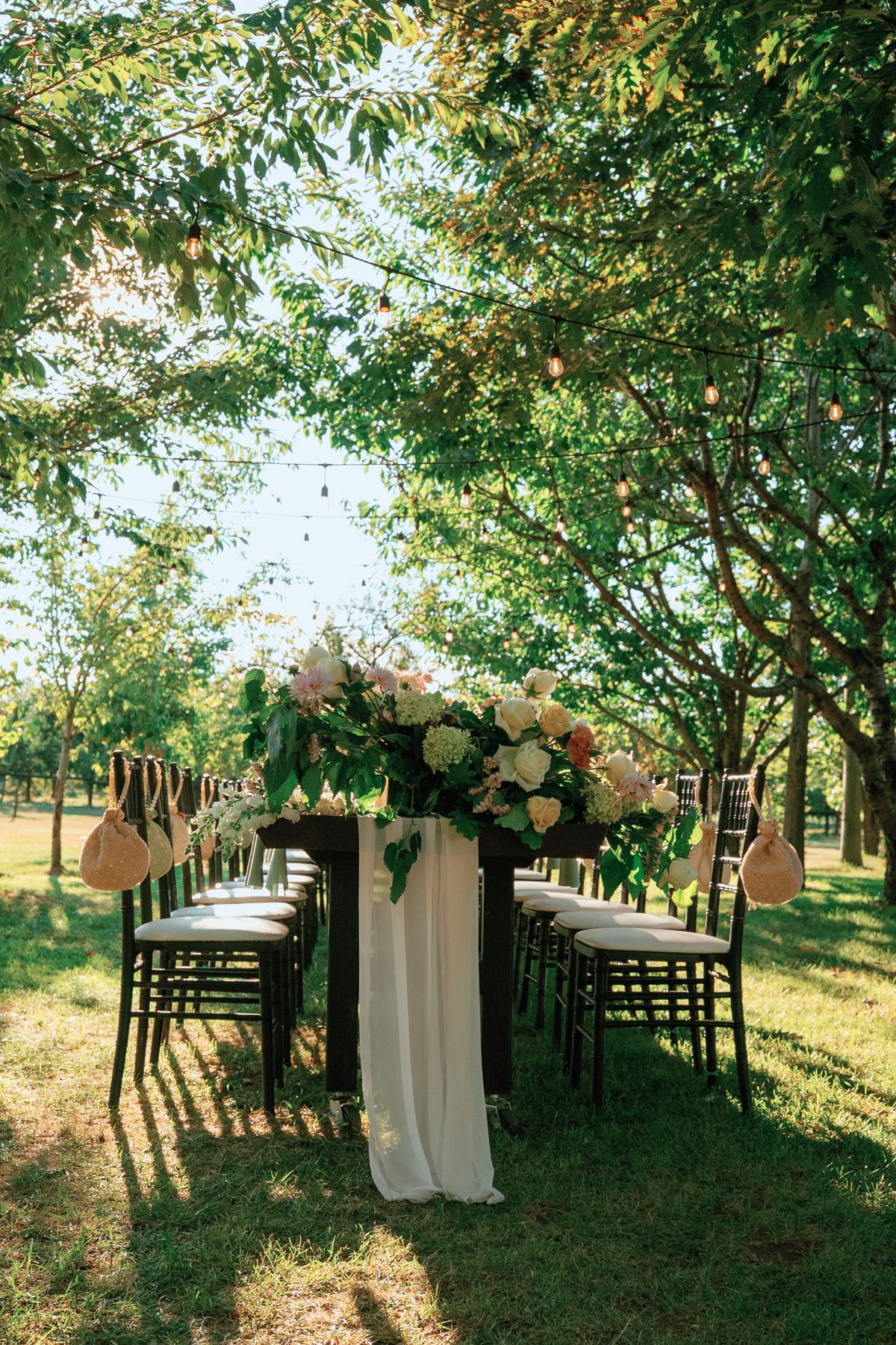 Elegant outdoor reception table with white florals, draping, and Chiavari chairs at Kurtz Orchards in Niagara-on-the-Lake.