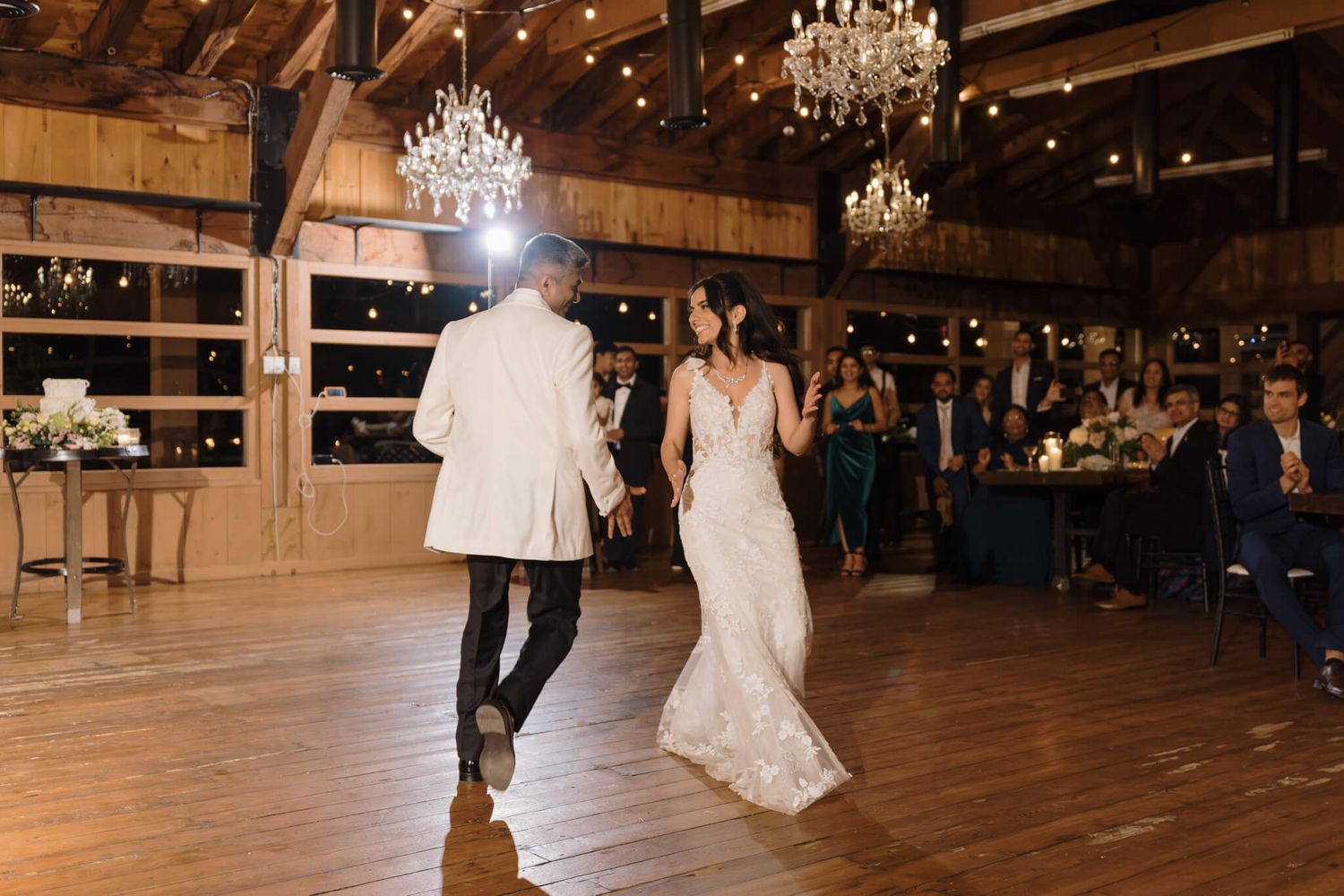 Bride and groom first dance beneath chandeliers and string lights at Kurtz Orchards in Niagara-on-the-Lake wedding reception.