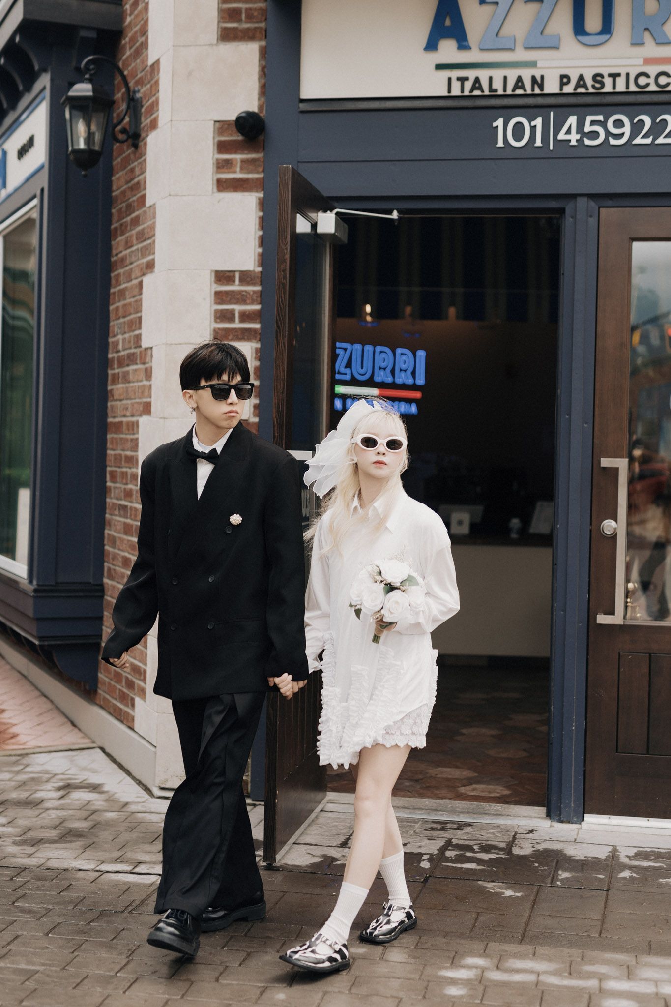Couple holding hands outside Azzurri Italian Pastry during a Chilliwack pre-wedding shoot for Vancouver wedding photography
