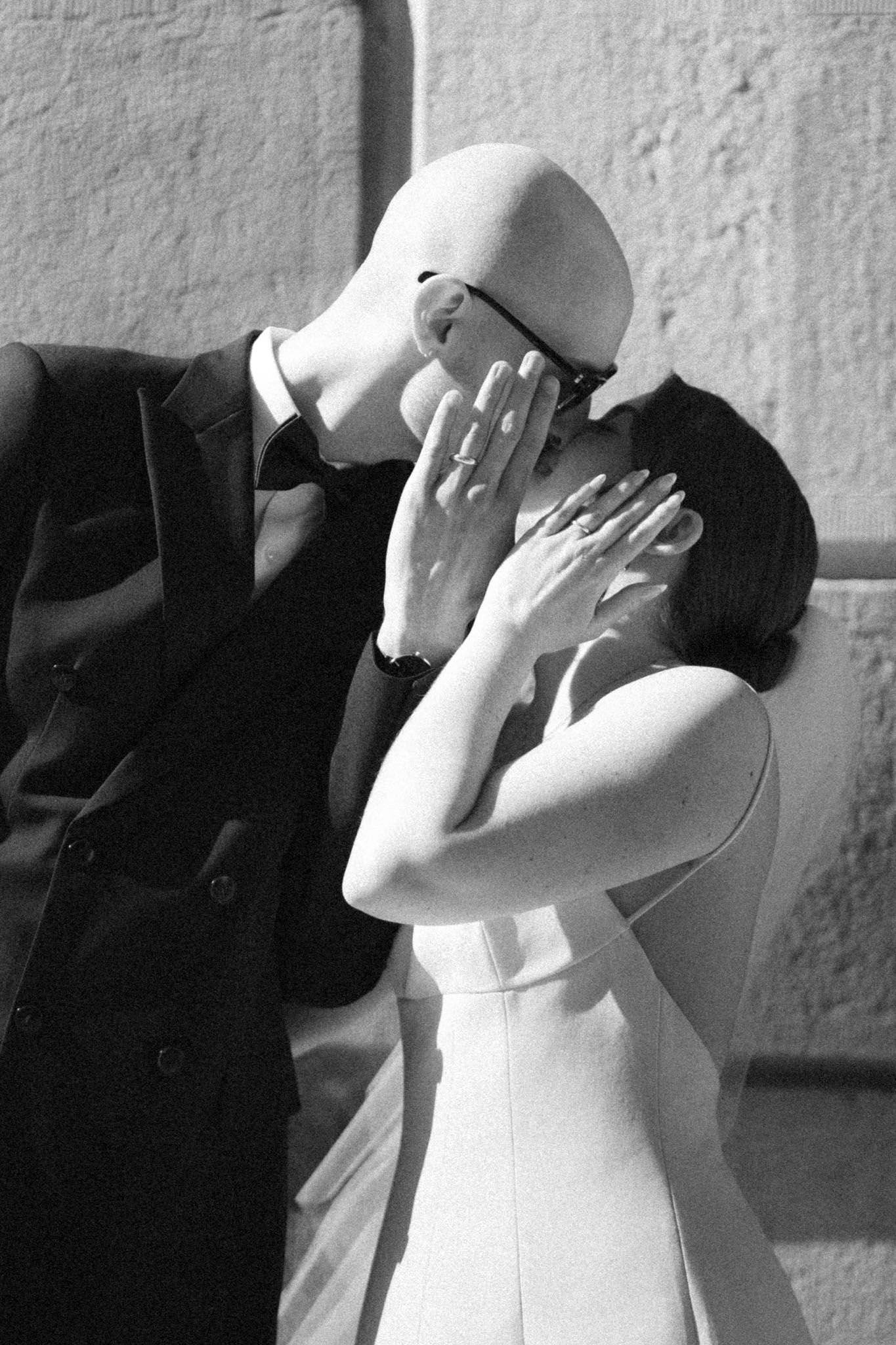 Black and white bride covering their faces as they kiss outside Osgoode Hall during a Toronto City Hall wedding