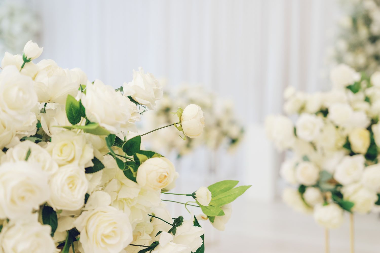 White rose floral arch with officiant and attendant in red at Bellamy Loft in North York, Toronto wedding ceremony.