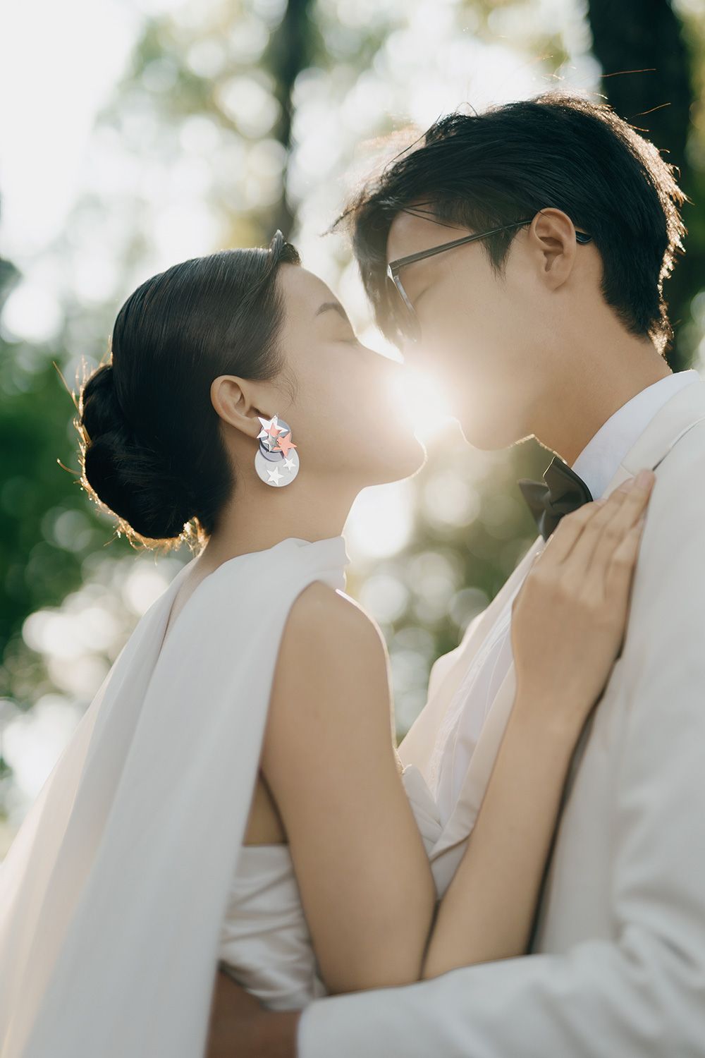Bride and groom sharing a golden hour almost-kiss outdoors during their wedding portrait session for romantic wedding photography