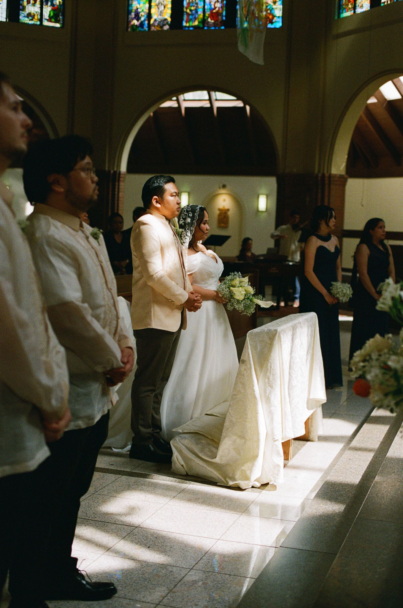 Bride and groom kneeling at the altar during their Catholic wedding at St. Joseph’s Parish in Langley for Vancouver wedding photography