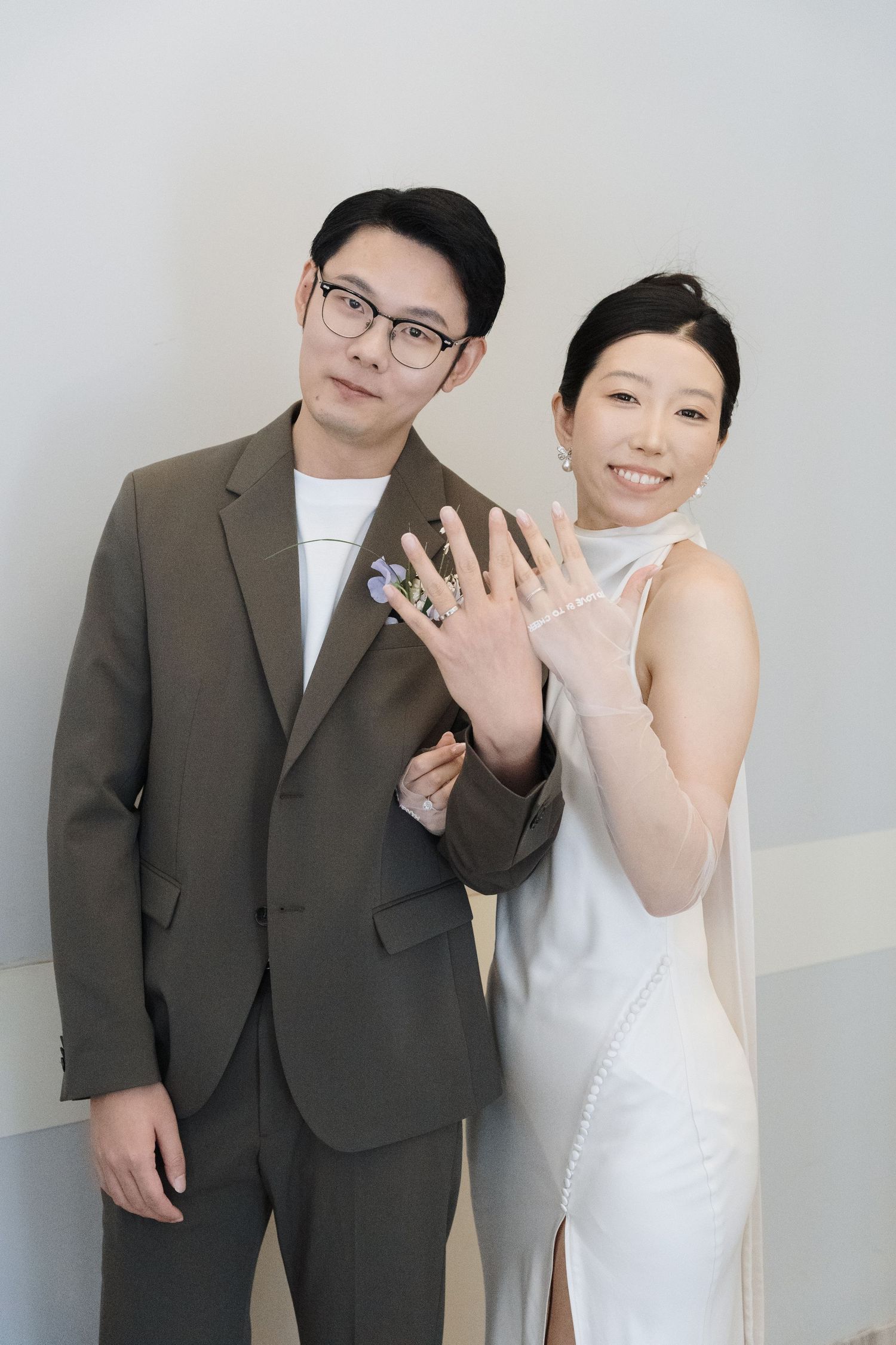 Couple smiling and showing wedding rings after their civil ceremony at Toronto City Hall for celebratory wedding photography.