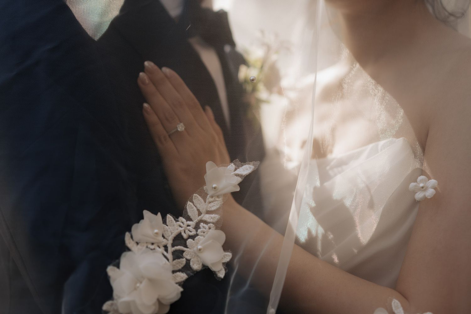 Editorial close-up of bride and groom with diamond ring, wrist corsage, and veil detail for Toronto wedding photography