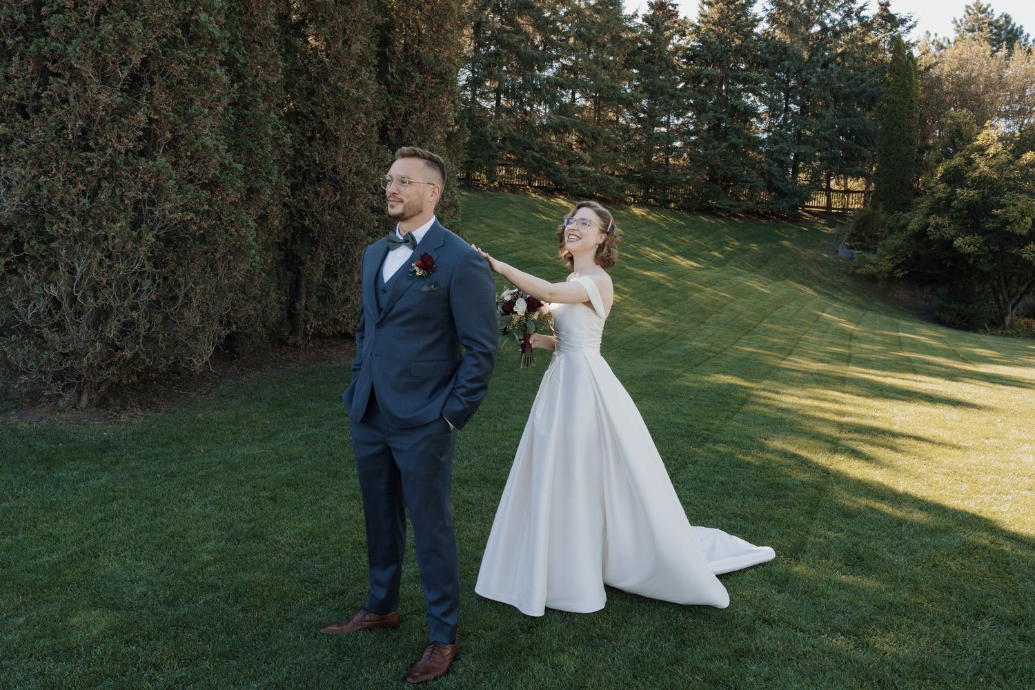 Bride touching groom’s shoulder during their first look on the lawn at The Manor in King City for Jewish wedding photography.