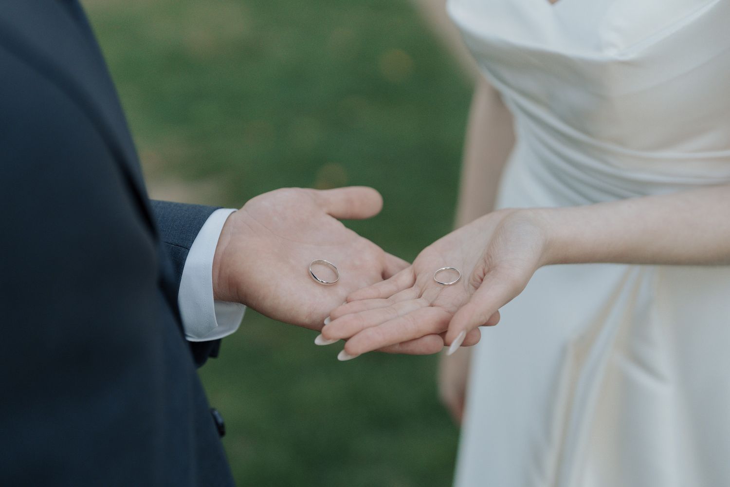 Bride and groom holding wedding rings in their palms during an outdoor Jewish wedding ceremony at The Manor in King City