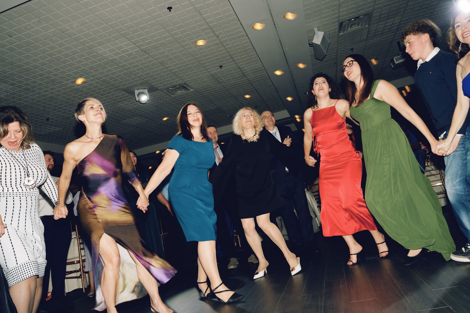 Elegantly dressed women dancing together during a wedding reception at The Manor Event Venue in King, Ontario