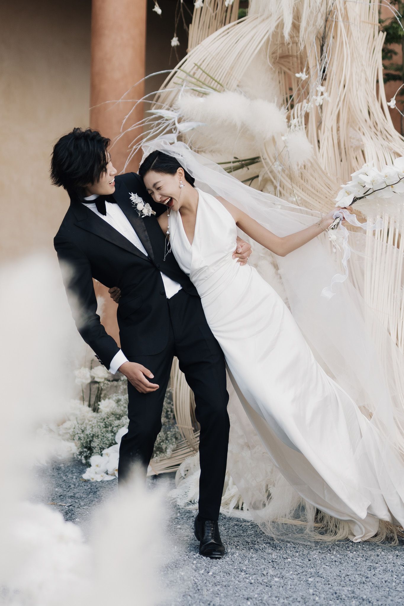Joyful bride and groom sharing a playful outdoor moment during their elegant destination wedding photography session