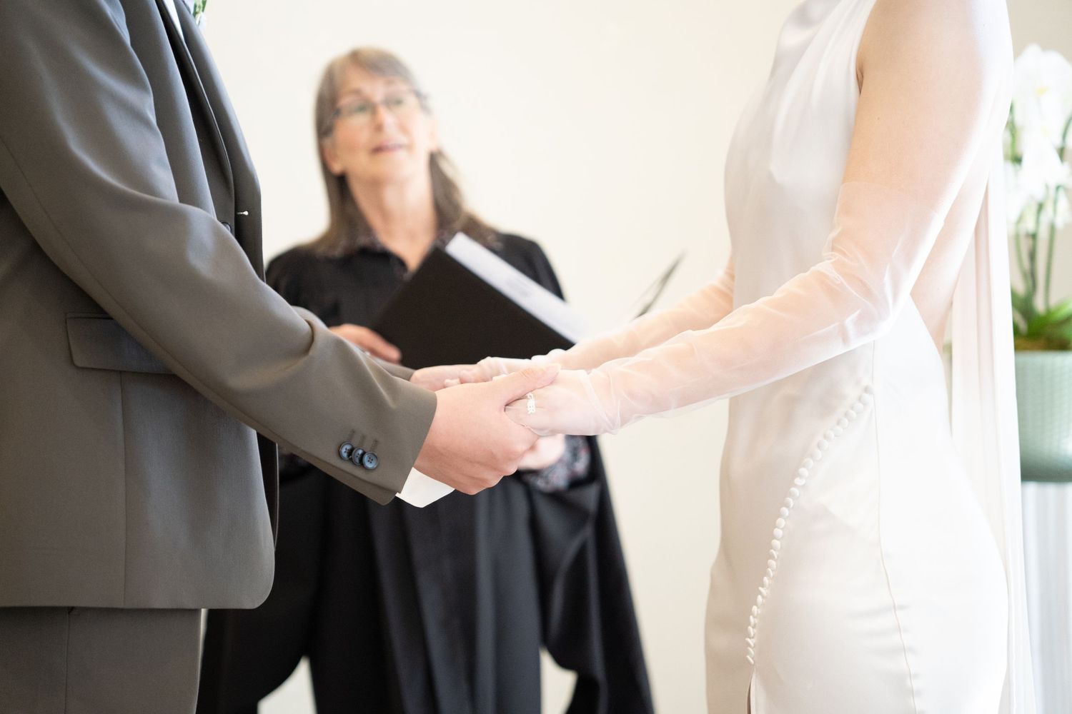 Bride and groom holding hands with officiant during a joyful post-ceremony moment at Toronto City Hall.