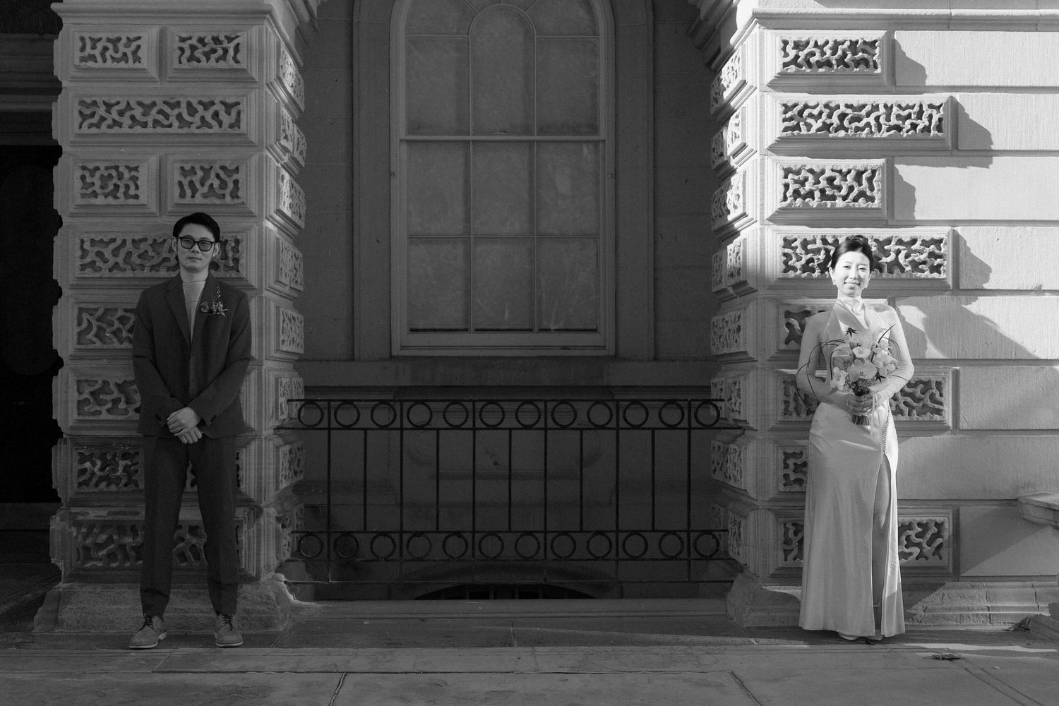 Black and white Chinese City Hall wedding portrait outside Osgoode Hall in Toronto, groom in shadow and bride in sunlight