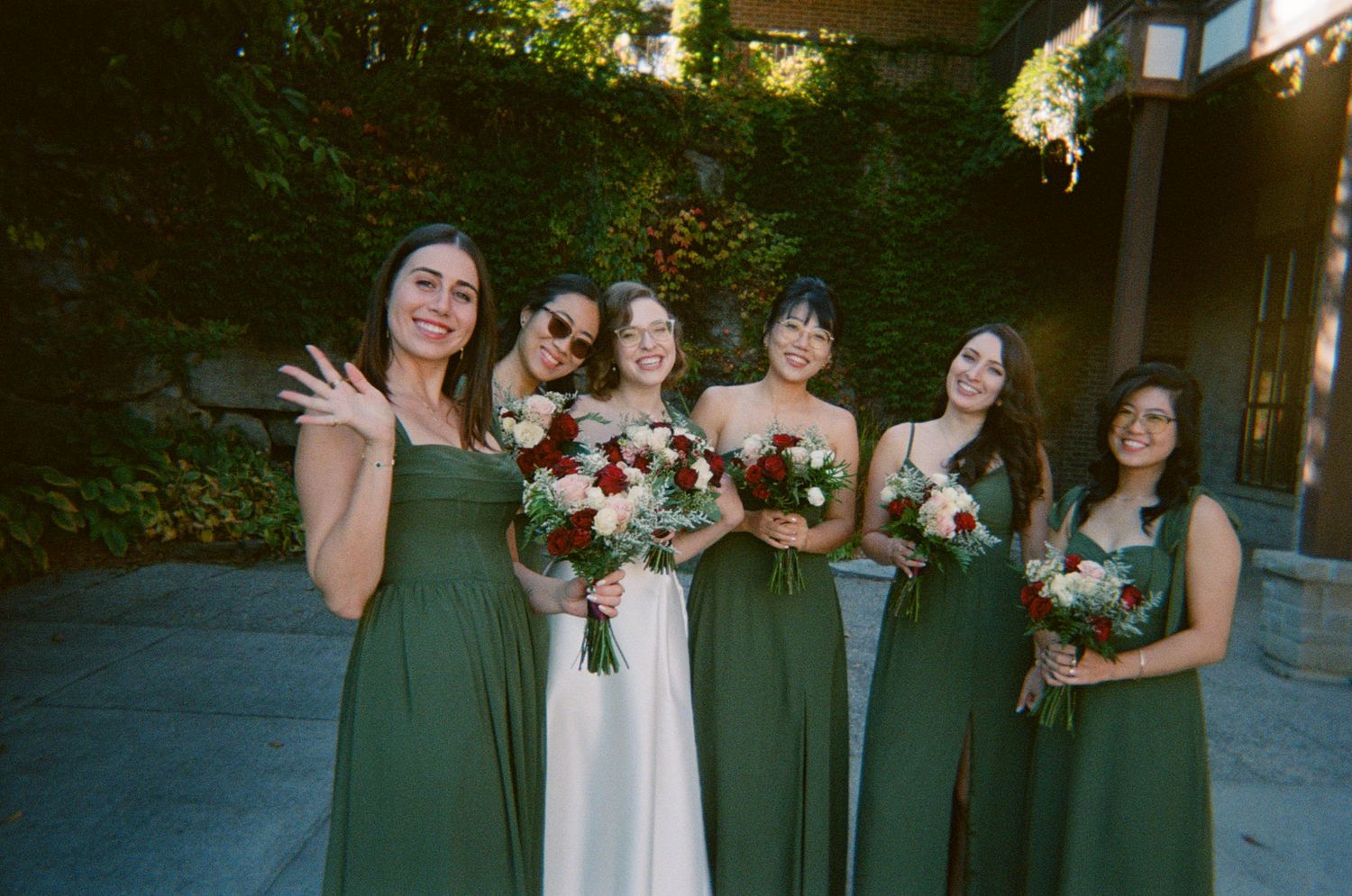 Bride with bridesmaids in sage green holding bouquets outdoors at The Manor in King City for Jewish wedding photography