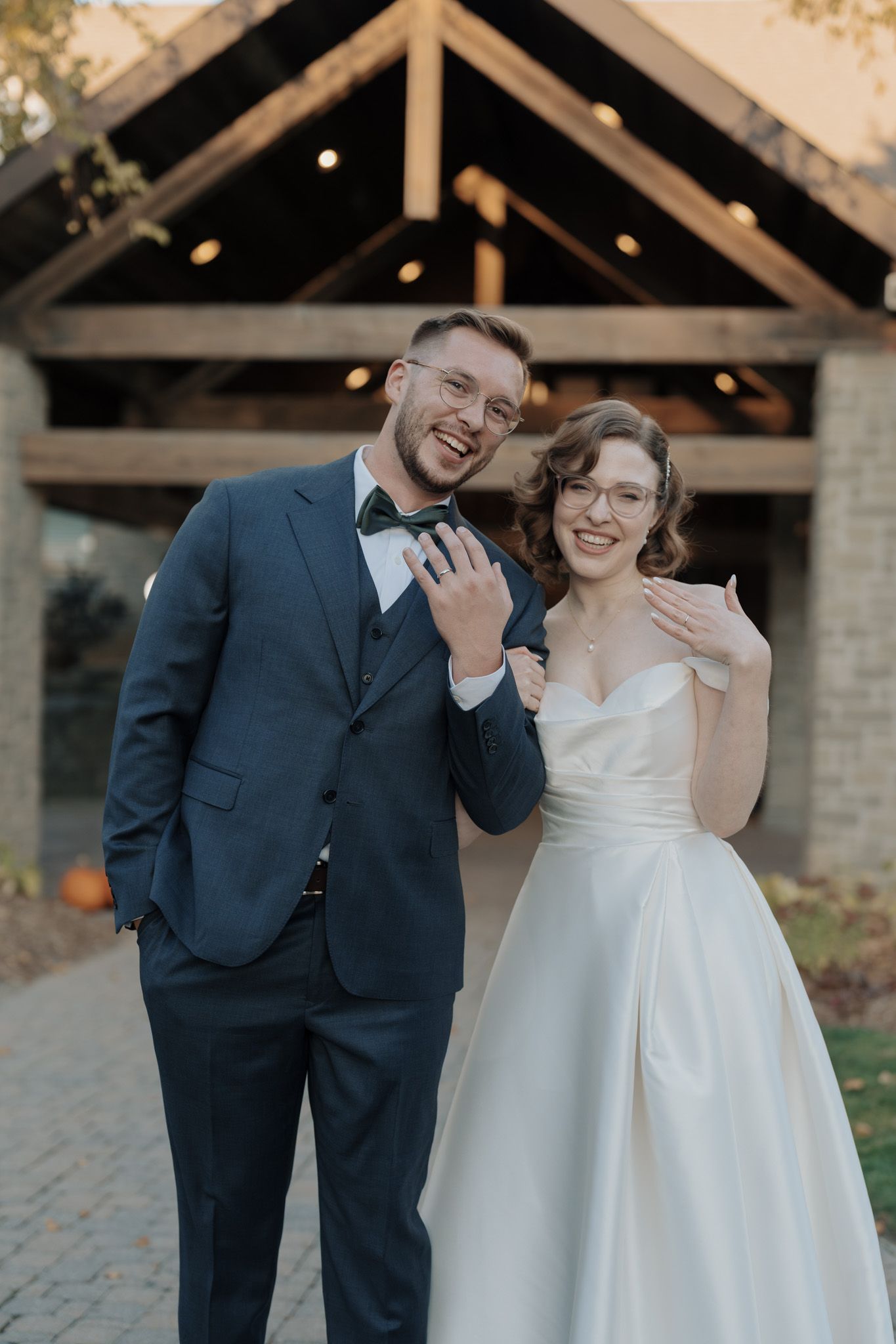 Newlyweds showing their wedding rings outside The Manor in King City during their joyful Jewish wedding celebration.