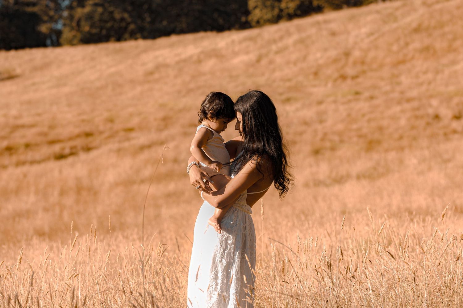 Precious moment captured between mum and toddler with noses touching, side face profile.