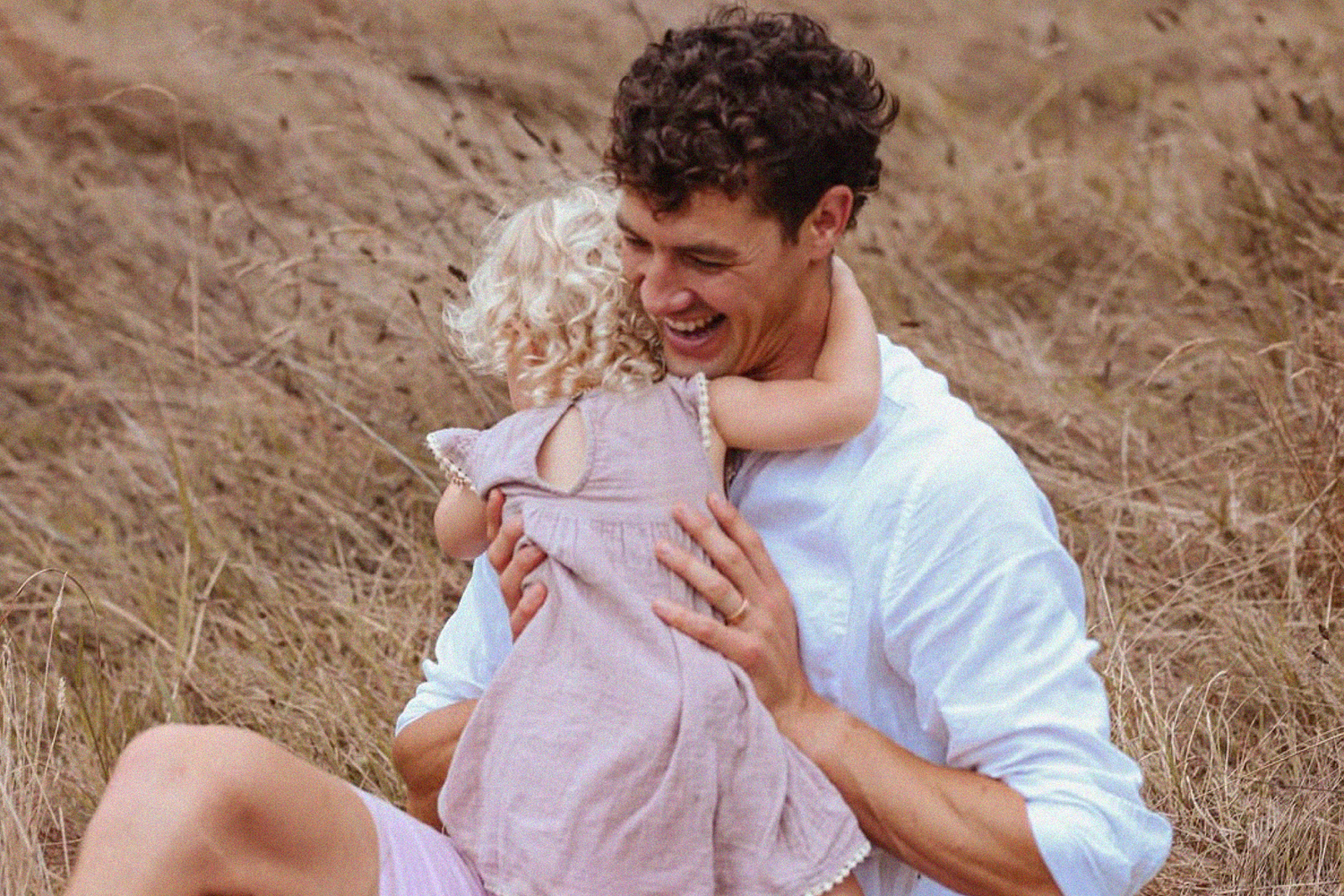 Family session at Cornwall Park, Epsom. Toddler girl hugging dad.