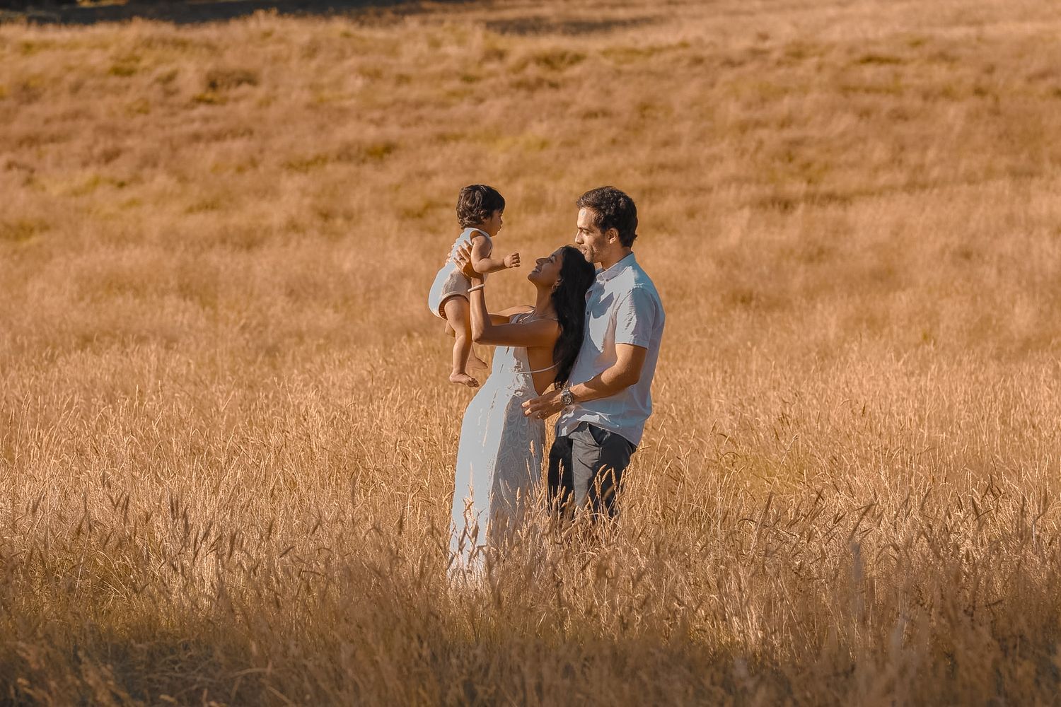 Soft-focus portrait of a mother and child in a meadow.