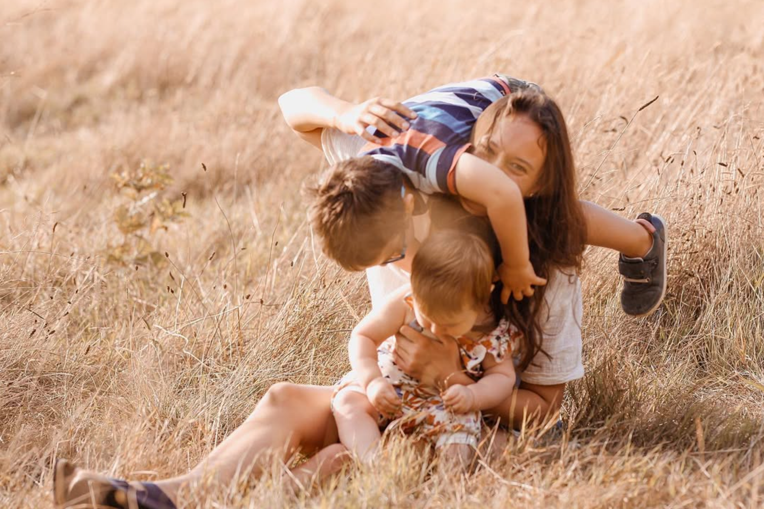 Auckland family photographer capturing a sunset session at Cornwall Park. Wild photo of two toddlers and mum.