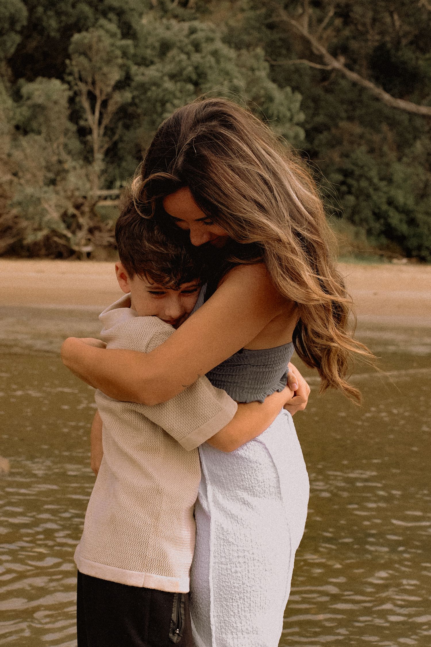 Beautiful moment of mother hugging son at long bay beach.