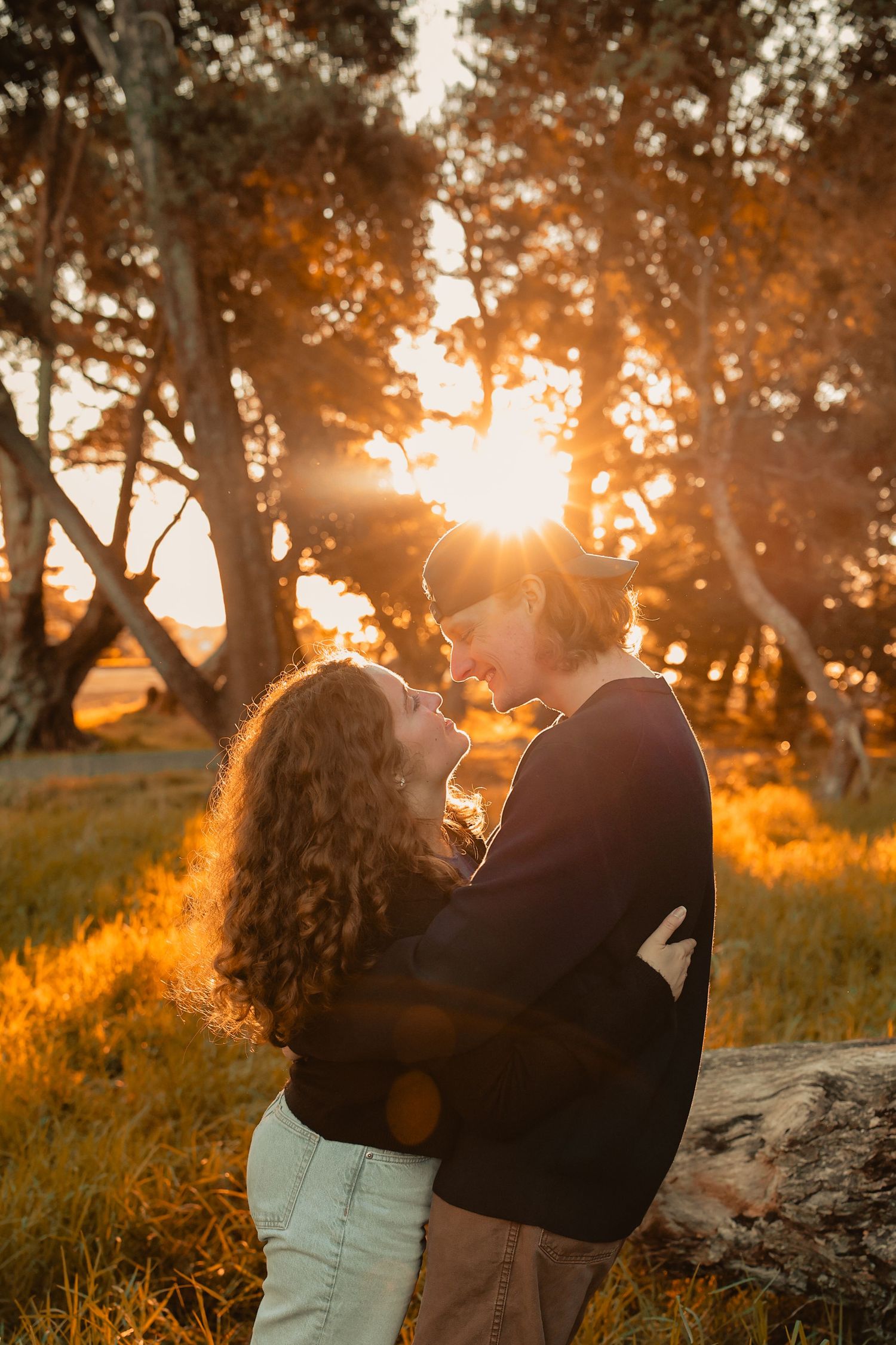 A playful couple, wide-open field, capturing authentic joy and movement.