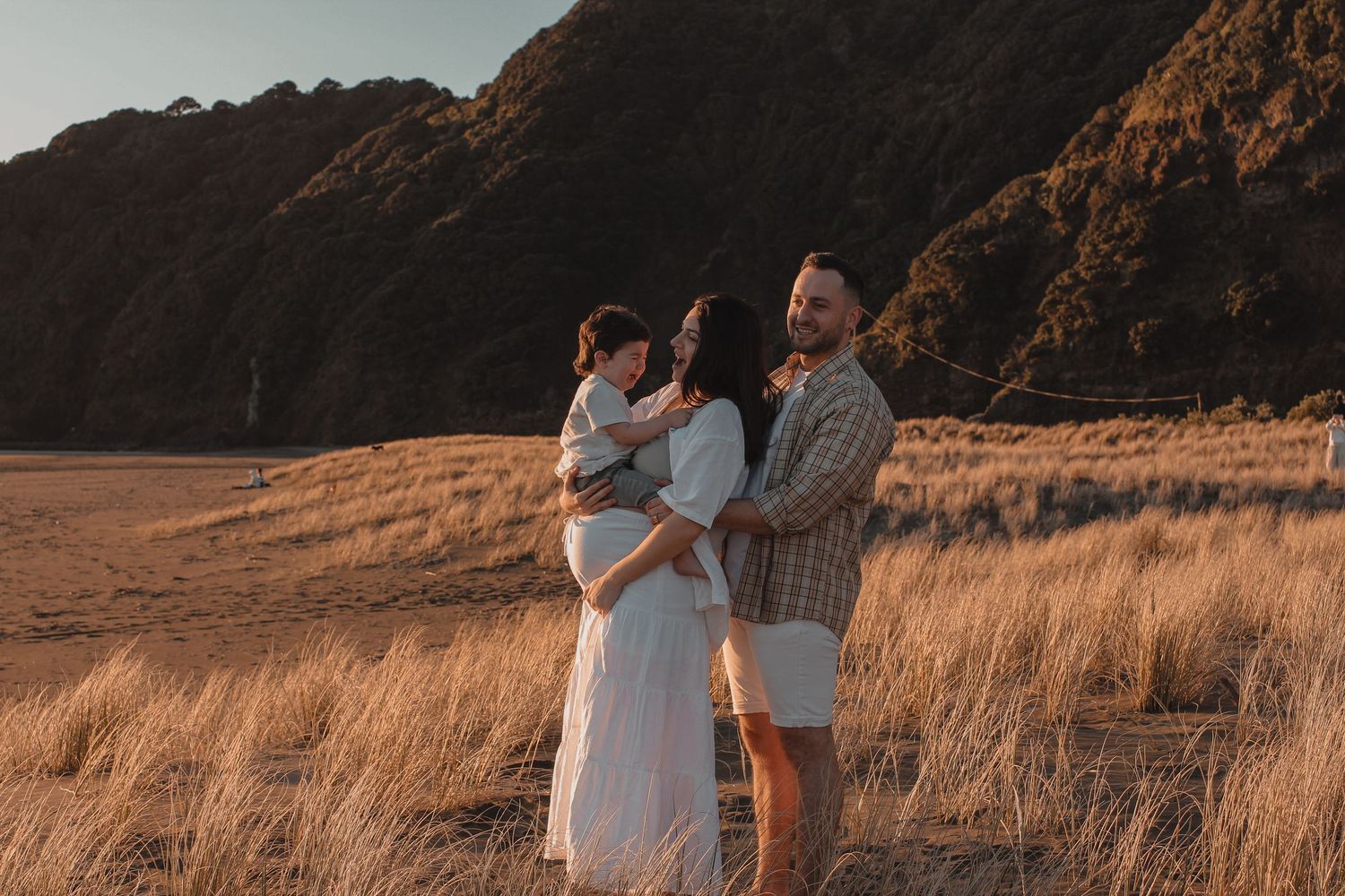 Sunset maternity photography session at Piha Beach.