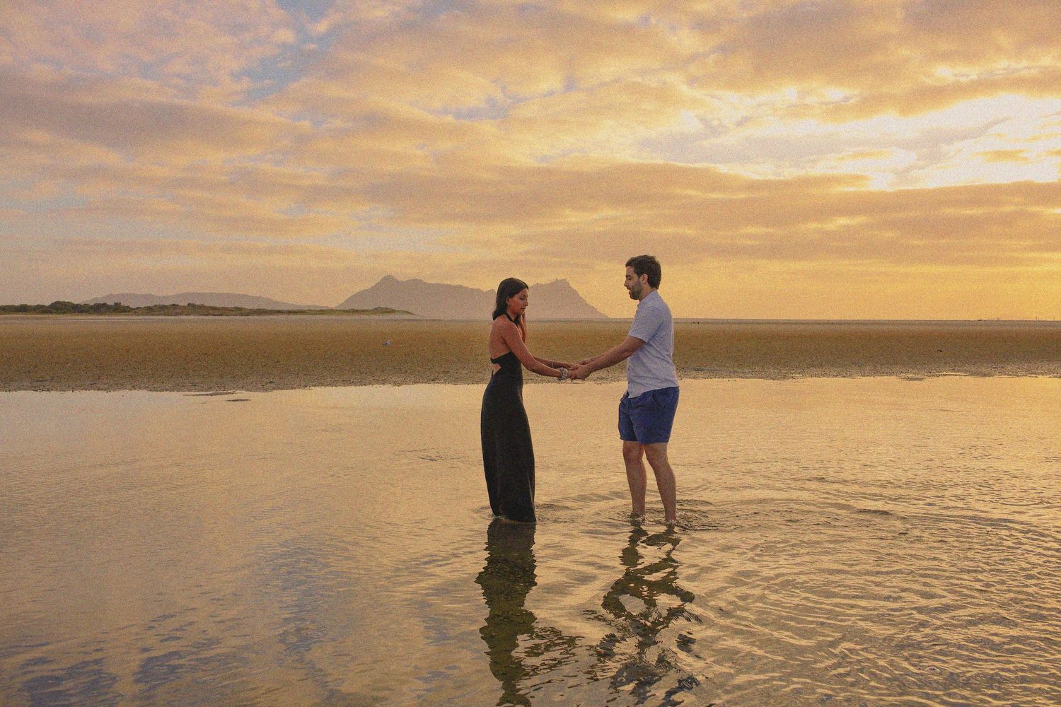 Sunset lifestyle session at Piha Beach with a family walking along the rugged West Coast shoreline.Romantic couples photoshoot.