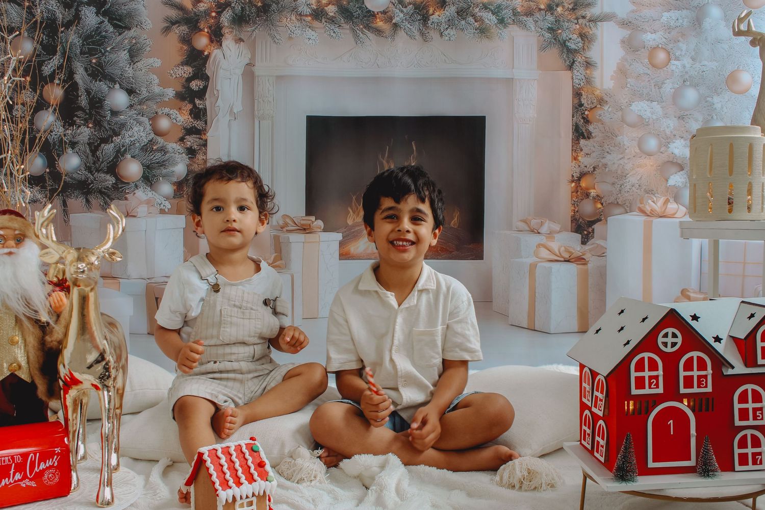 Toddler sitting on a white sheepskin rug in front of a boho-style Christmas set.
