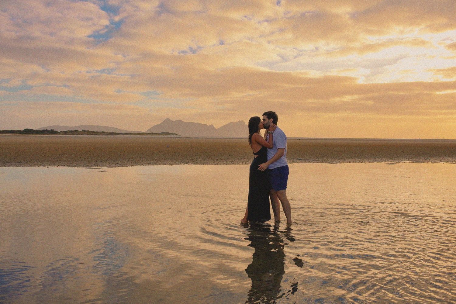 Beautiful sunset photo of couple during golden hour.  Kissing his love.