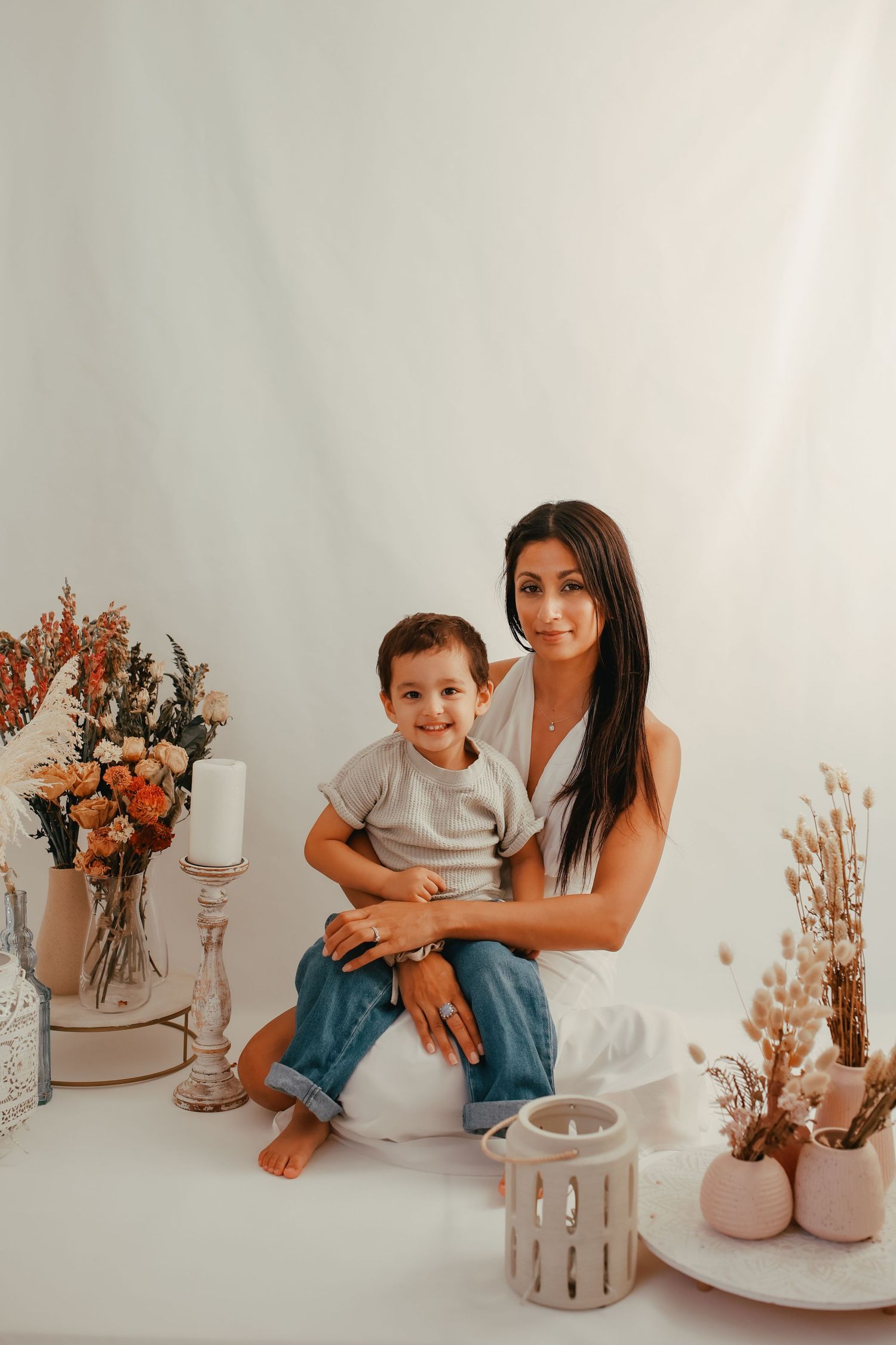 Mother’s Day photoshoot with a a floral backdrop and soft pastel colors and dried flowers.