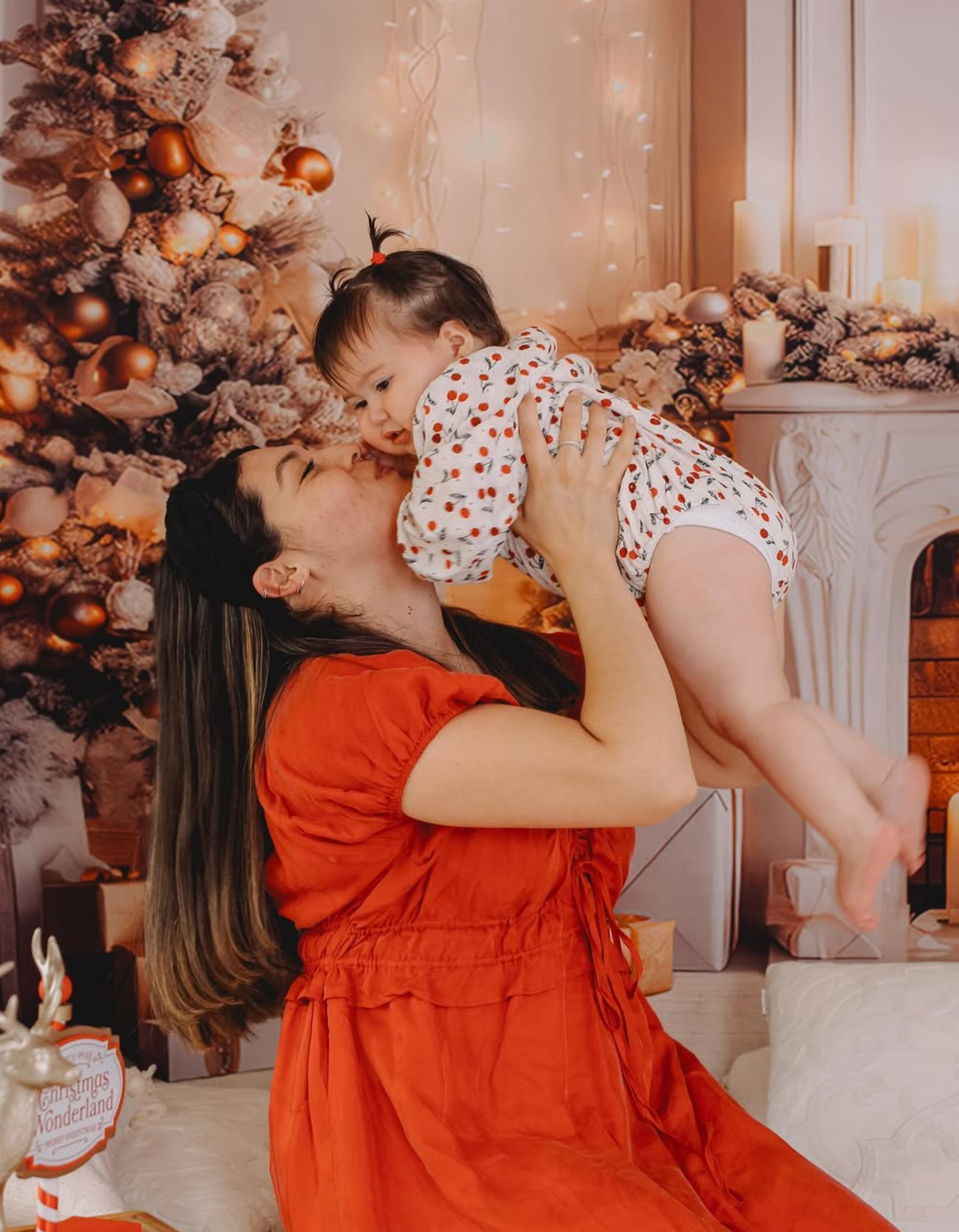 Mum in red dress kissing baby for Christmas mini session, Auckland.